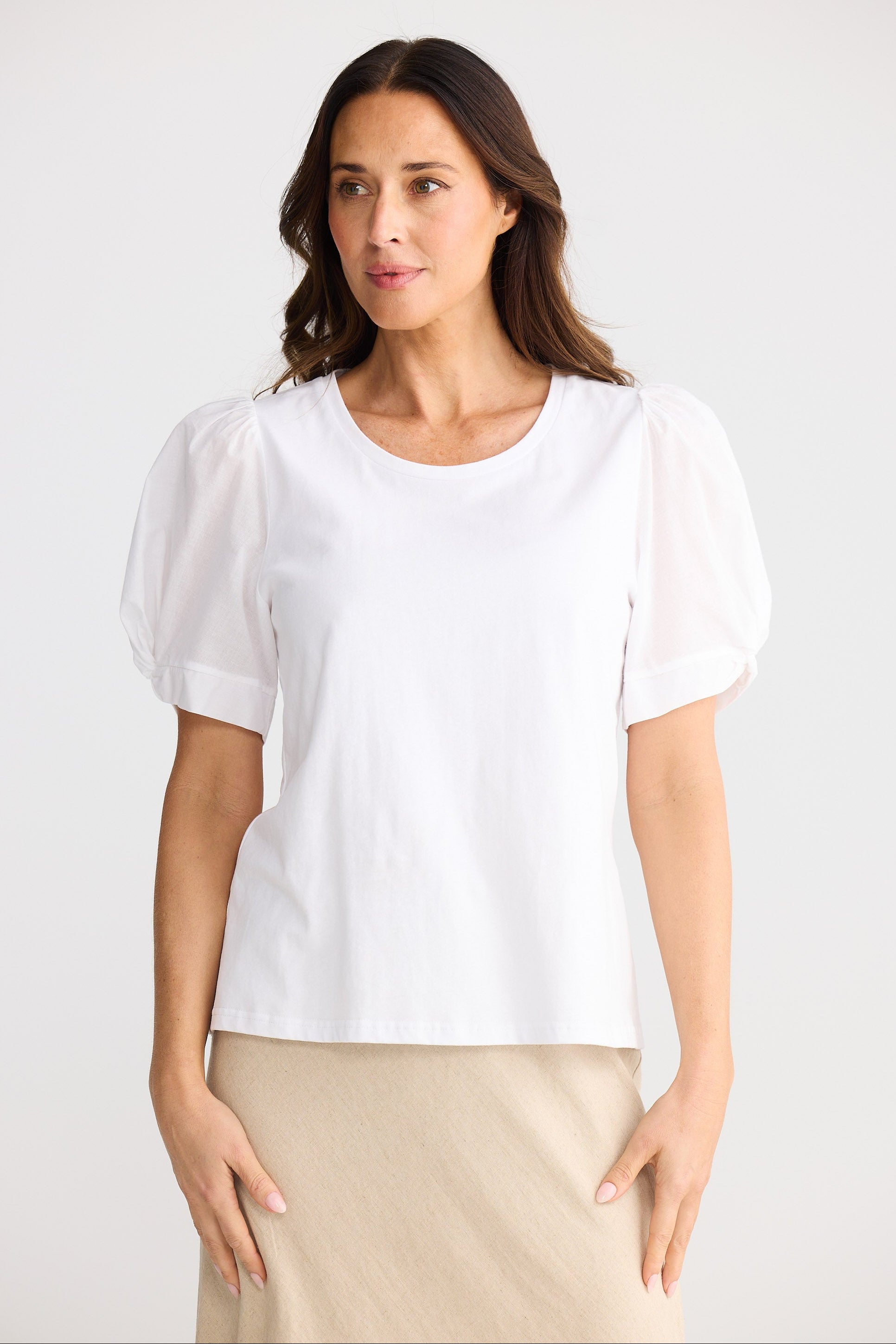 Woman wearing a white blouse against a plain background