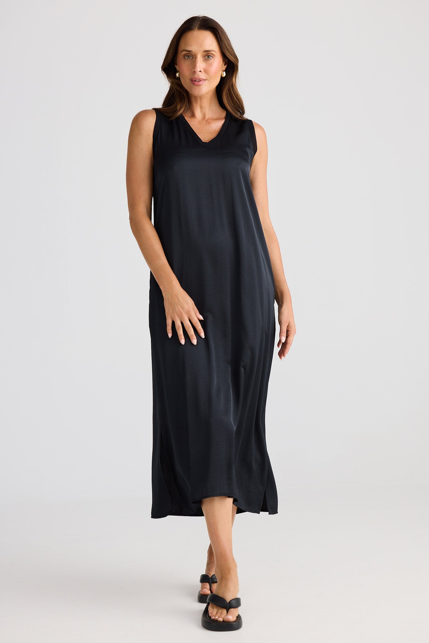 Woman wearing a black sleeveless dress on a white background