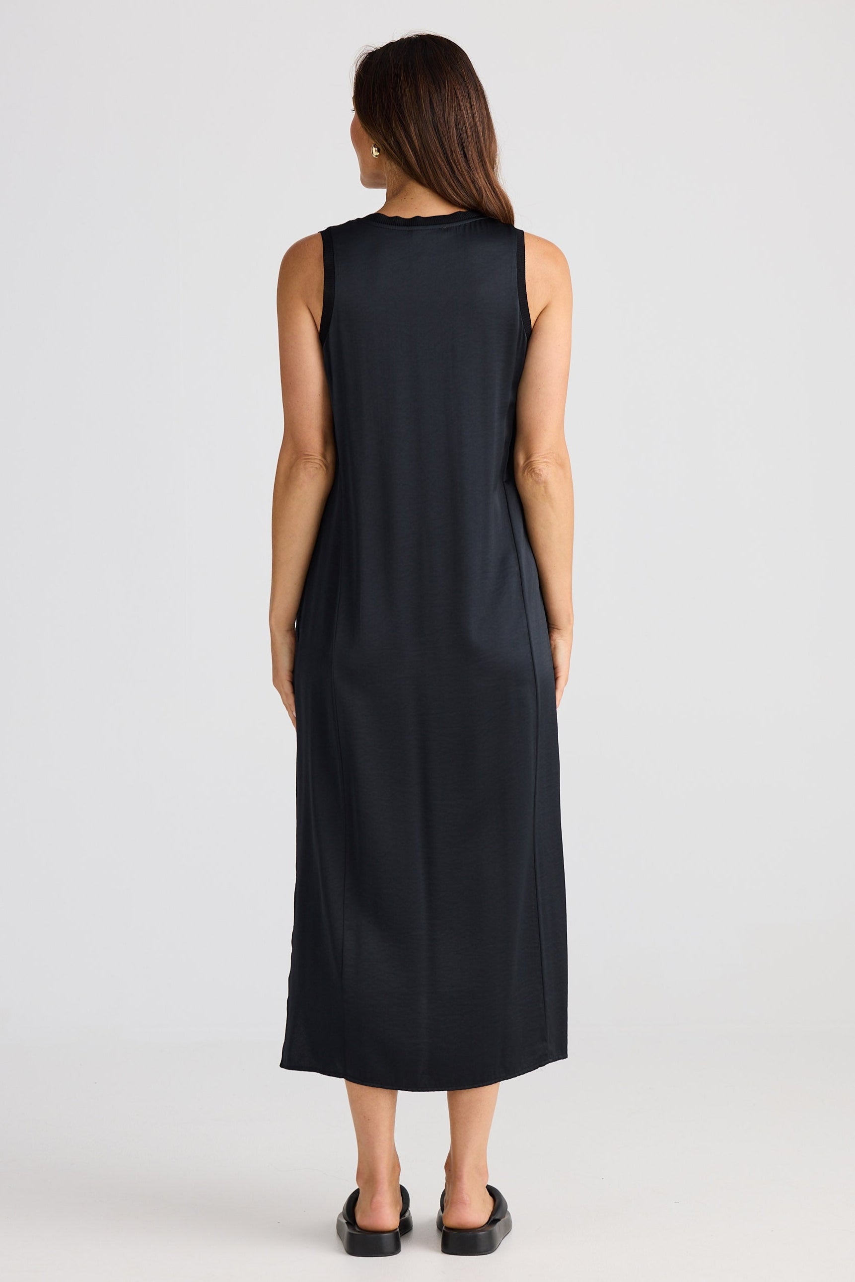 Woman wearing a black sleeveless dress on a white background