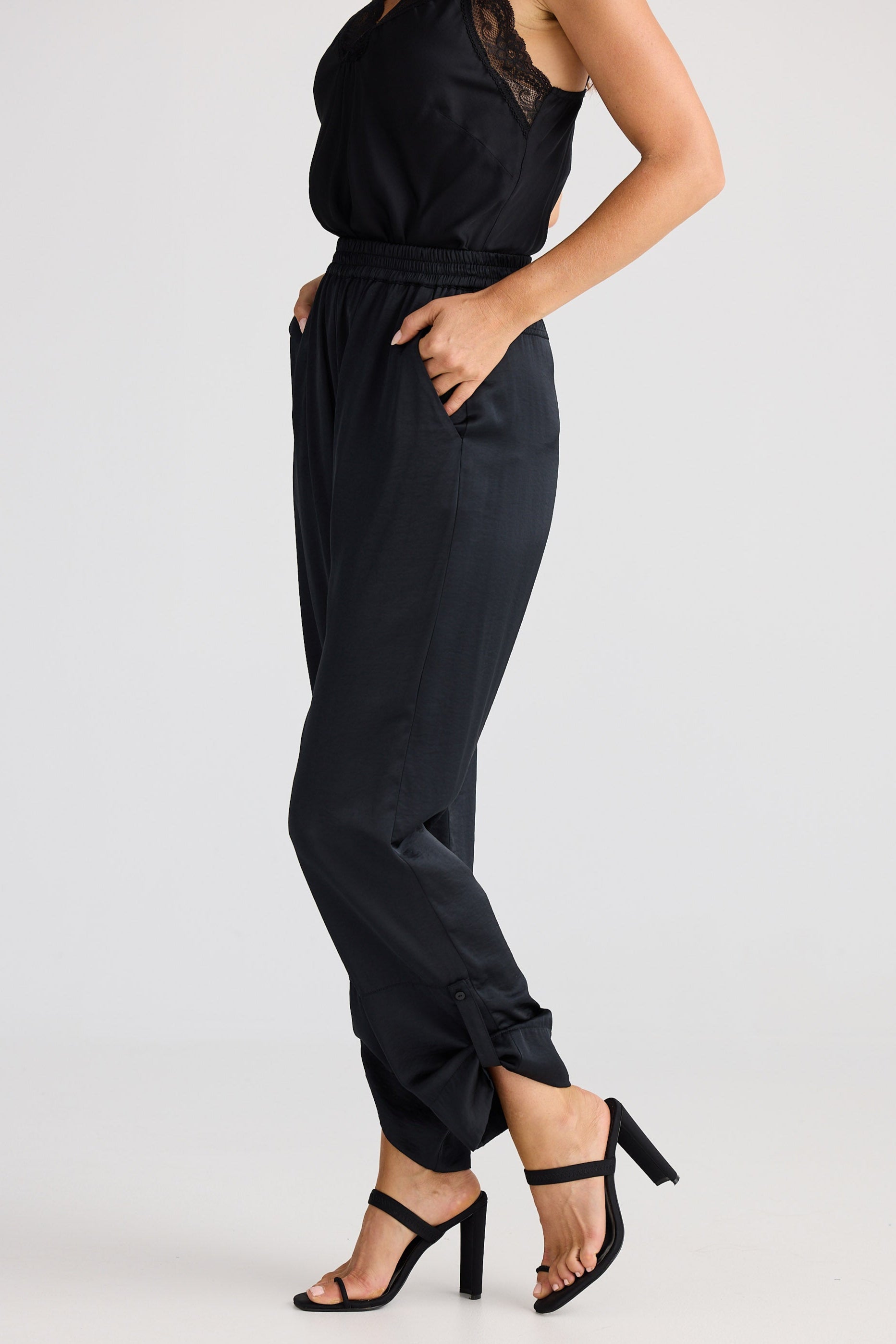 Black cami and pants worn by a person on a white background