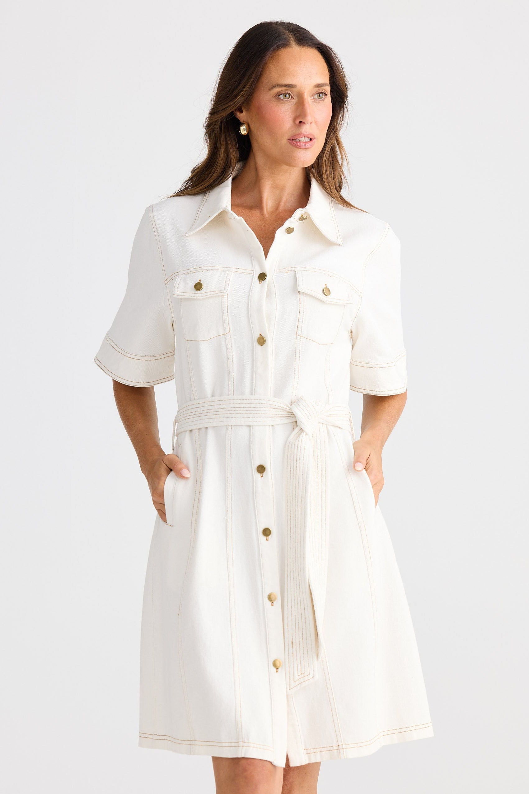 Woman wearing a white dress with buttons on a white background