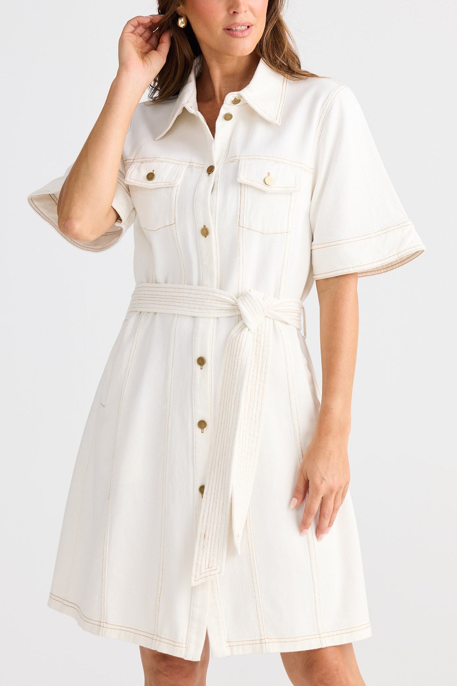Woman wearing a white dress with a belt on a white background