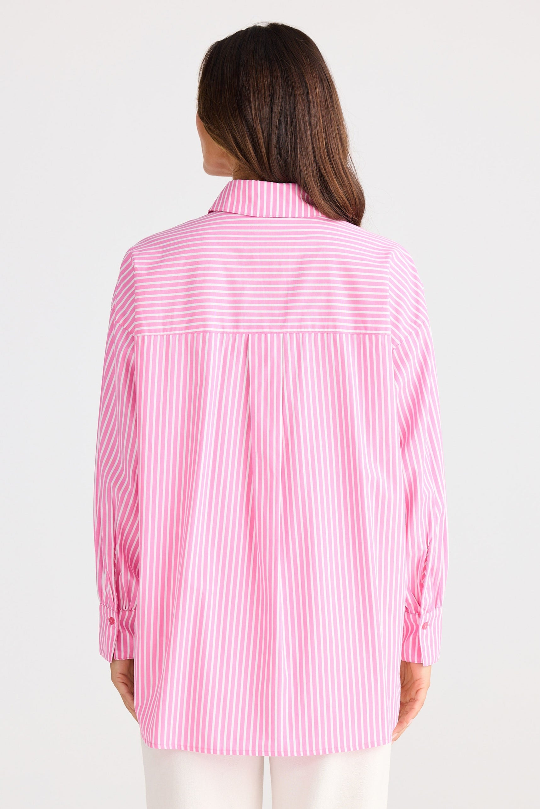 Person wearing a pink and white striped shirt on a white background