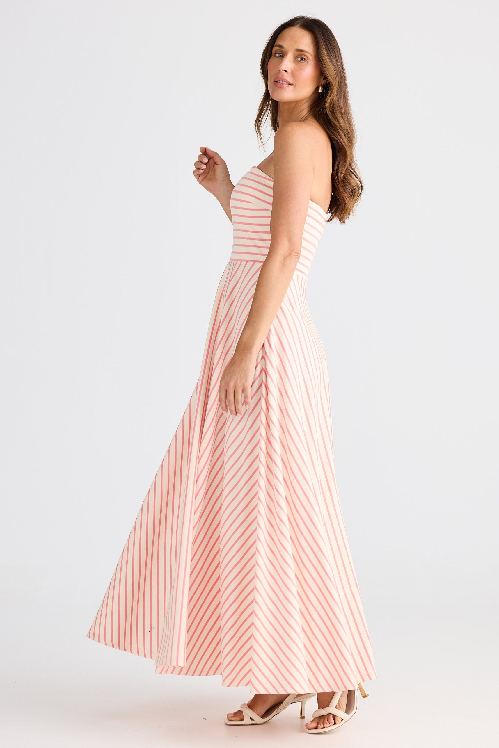 Woman wearing a pink and white striped dress on a white background