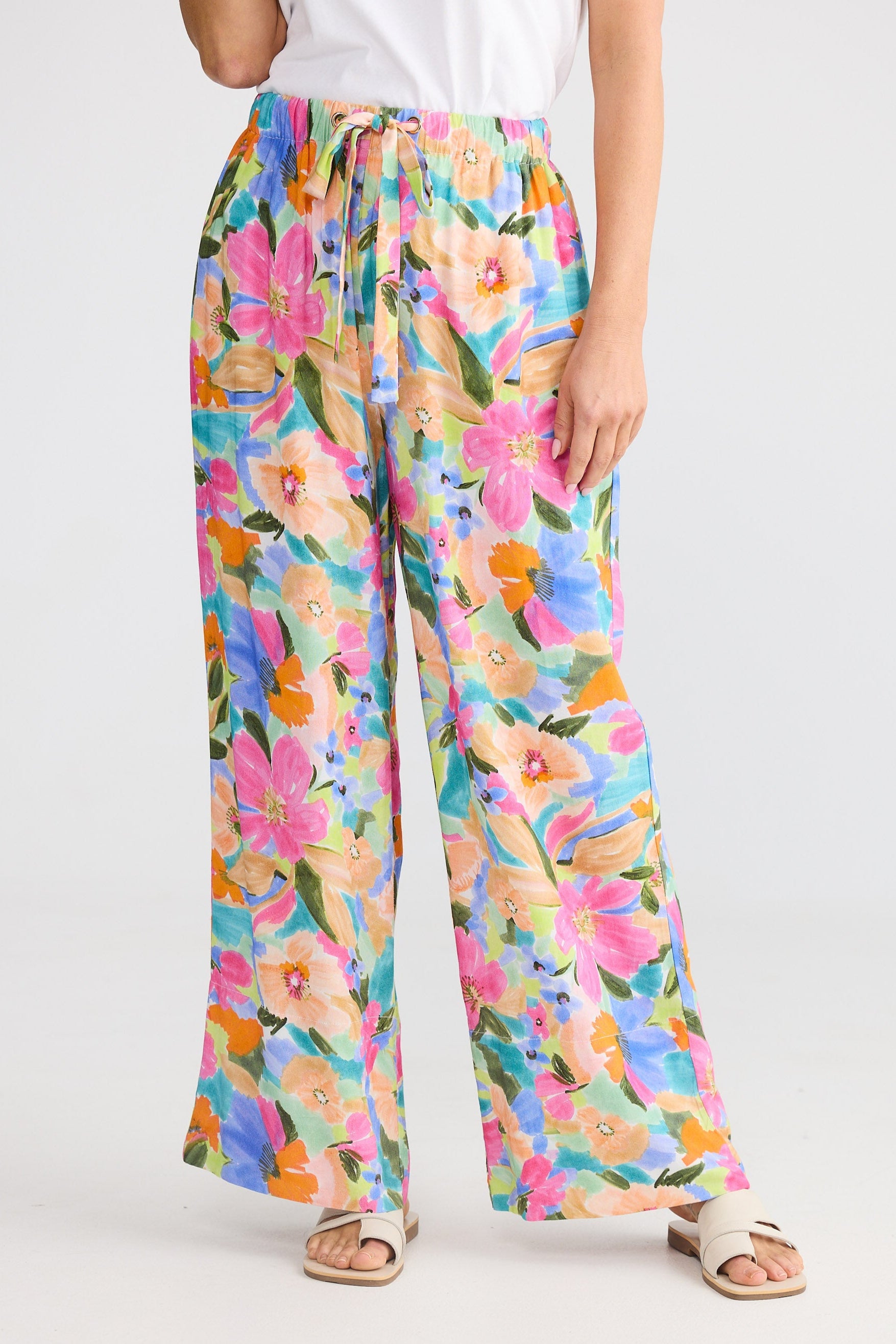 Colorful floral pants worn by a person on a white background