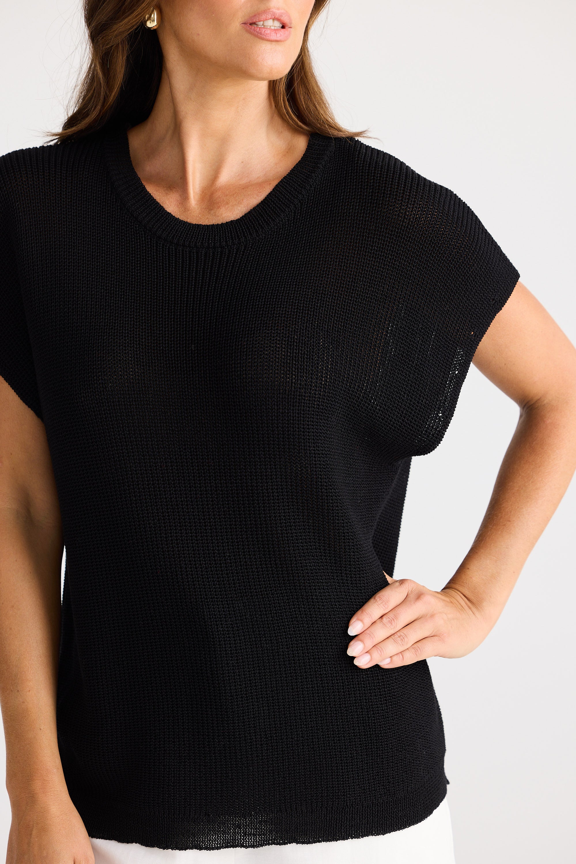 Woman wearing a black short-sleeve top against a white background