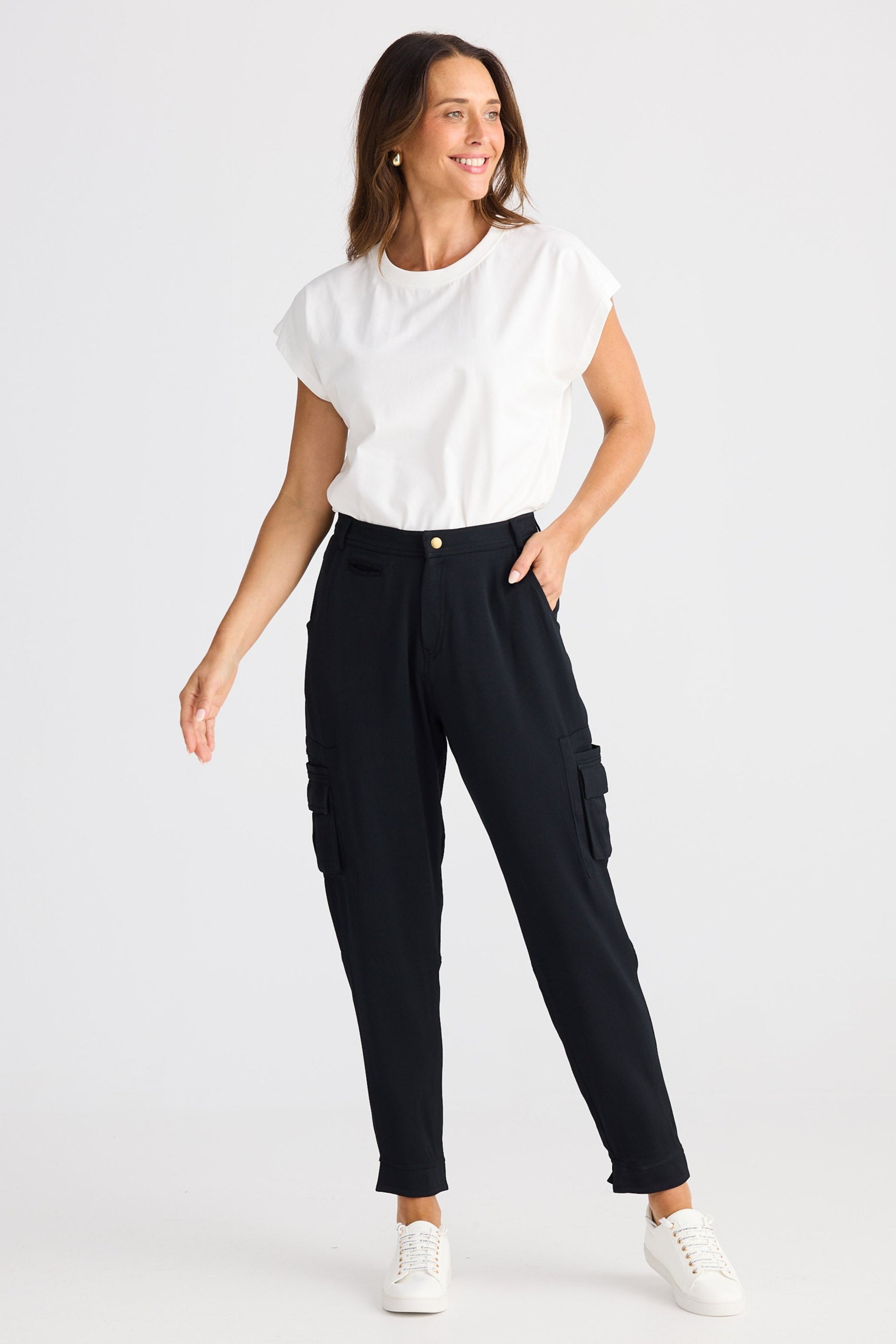 Woman wearing a white t-shirt and black pants on a white background
