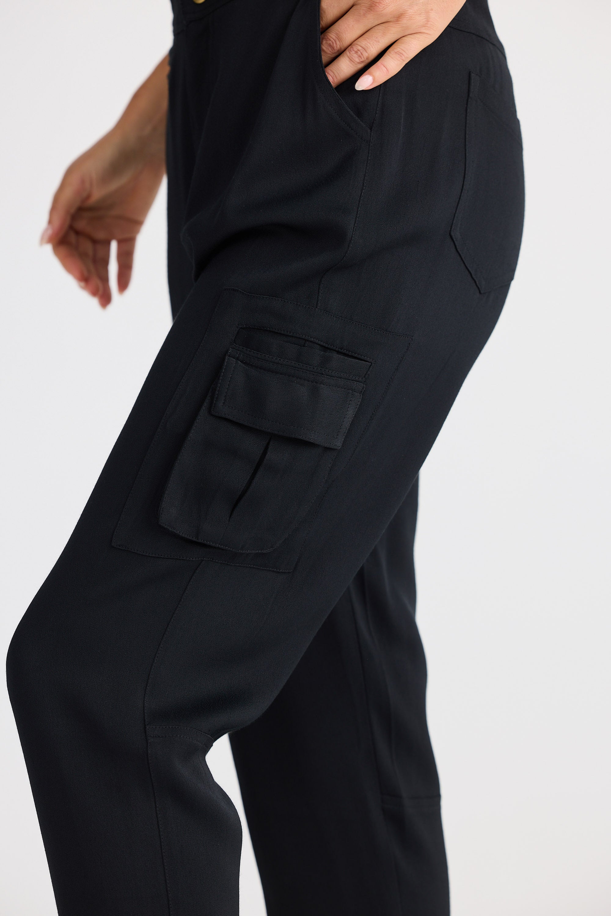 Black cargo pants with multiple pockets on a white background