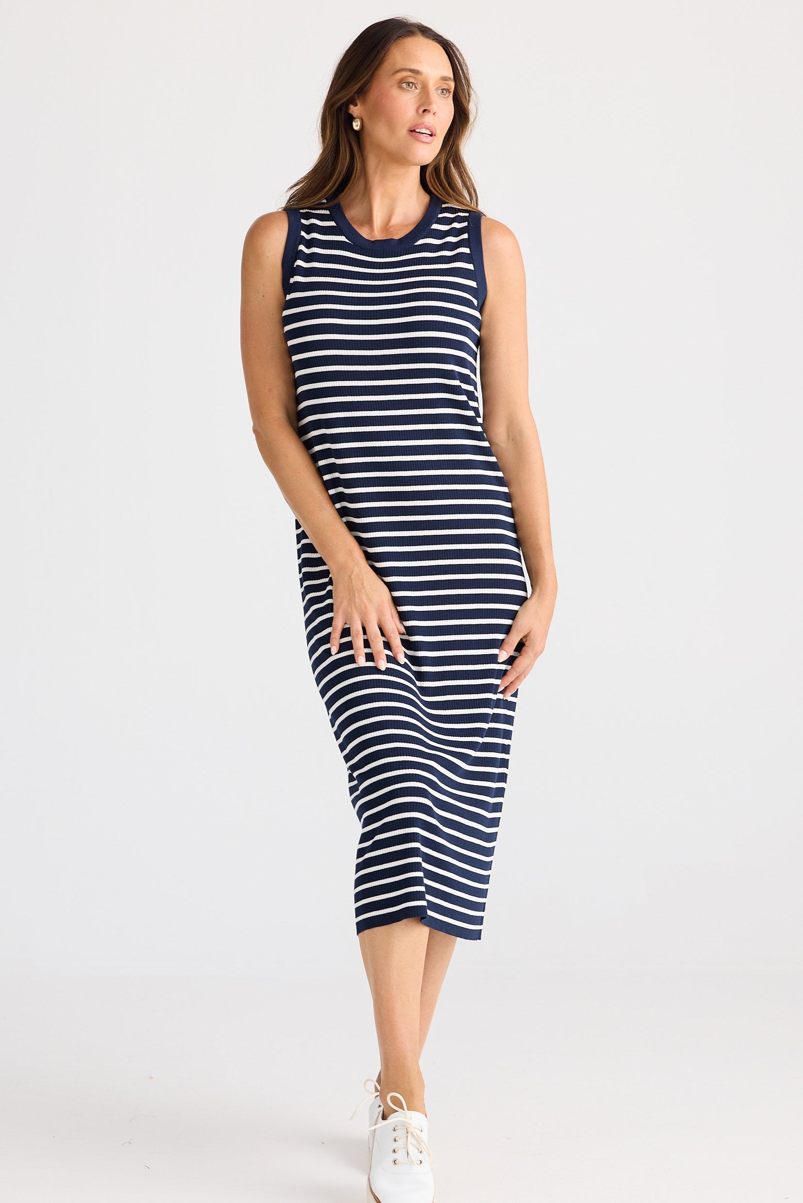 Woman wearing a navy and white striped dress on a white background