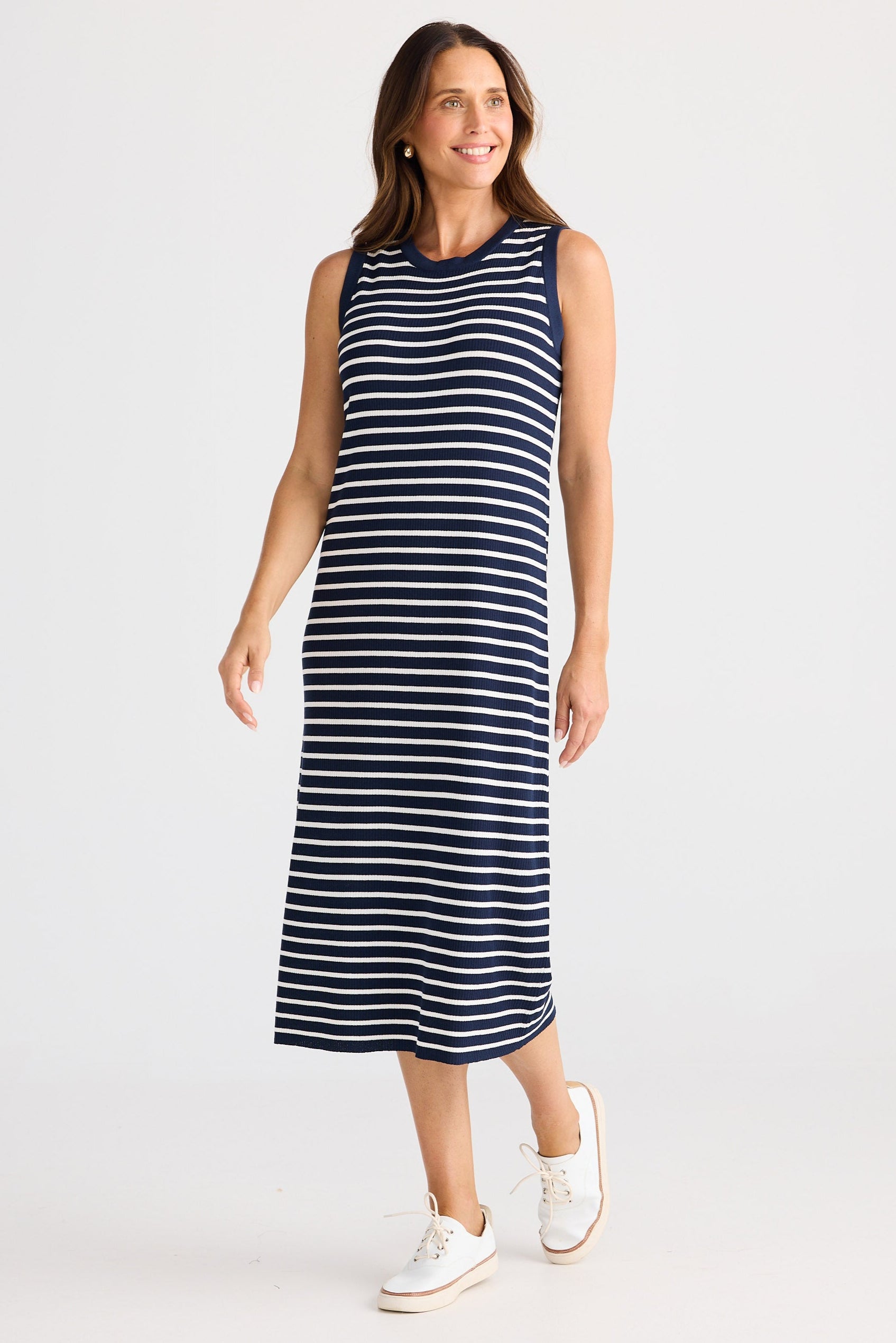 Woman wearing a navy and white striped dress on a white background