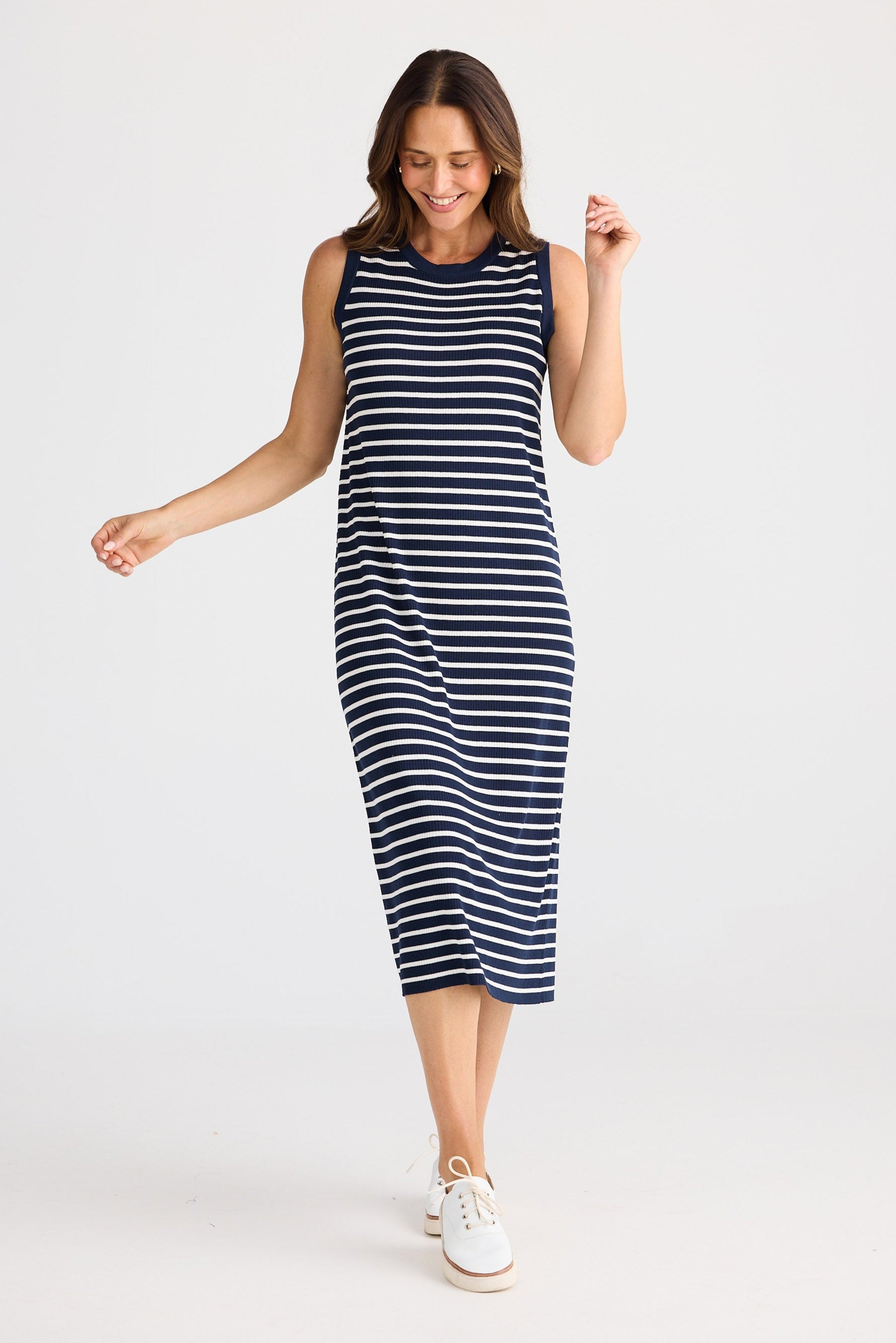 Woman wearing a navy and white striped dress on a white background