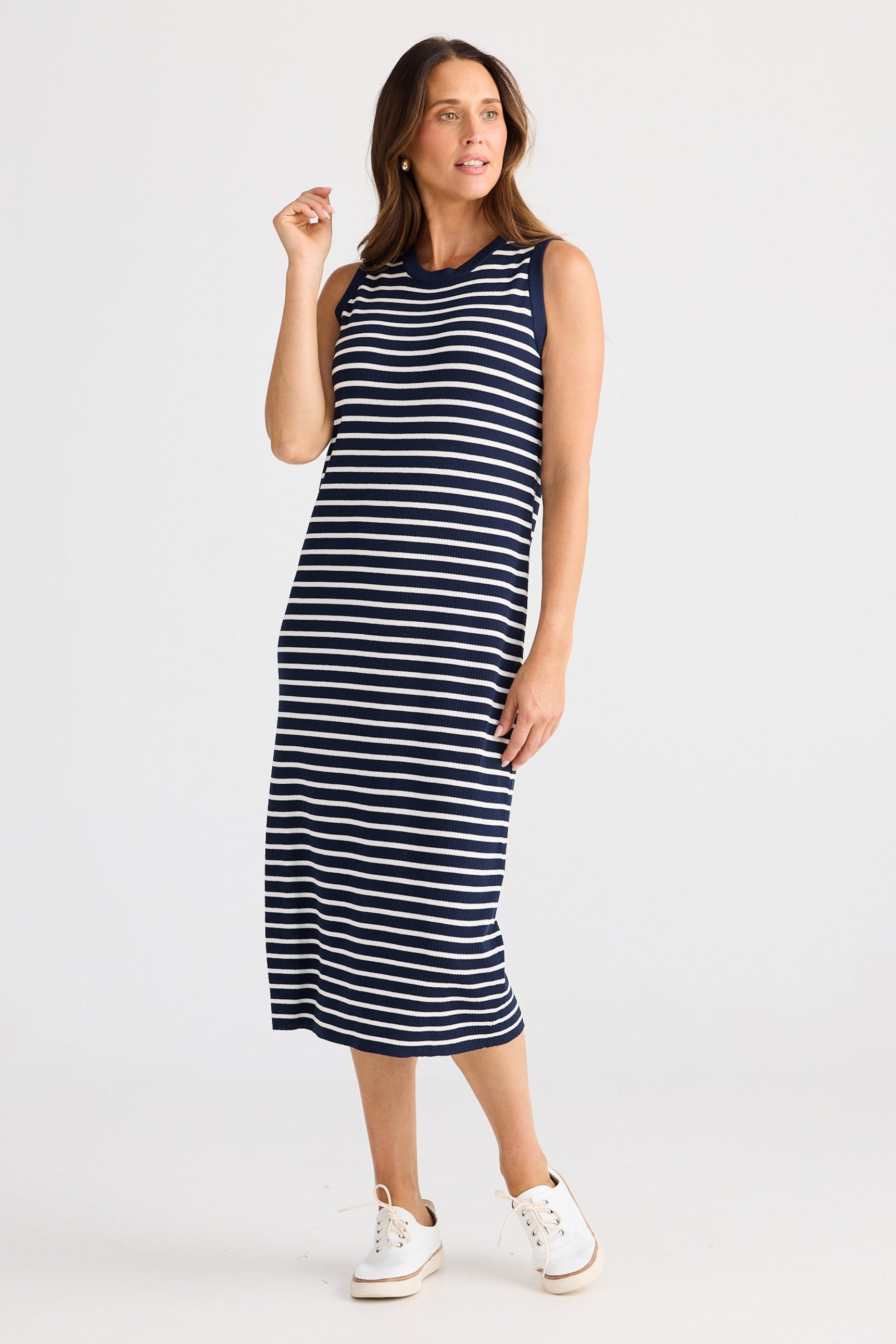 Woman wearing a navy and white striped dress on a white background