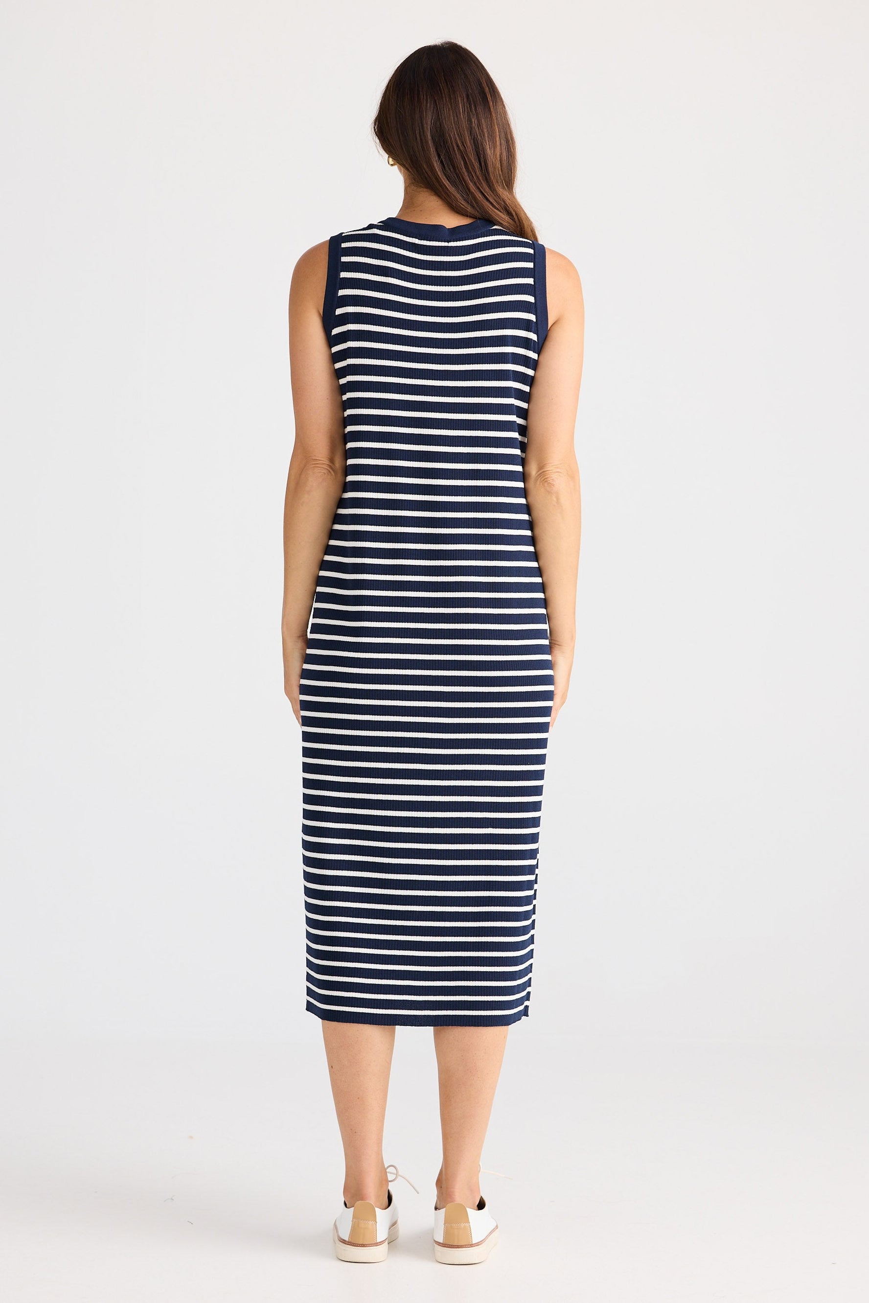 Woman wearing a navy and white striped dress on a white background