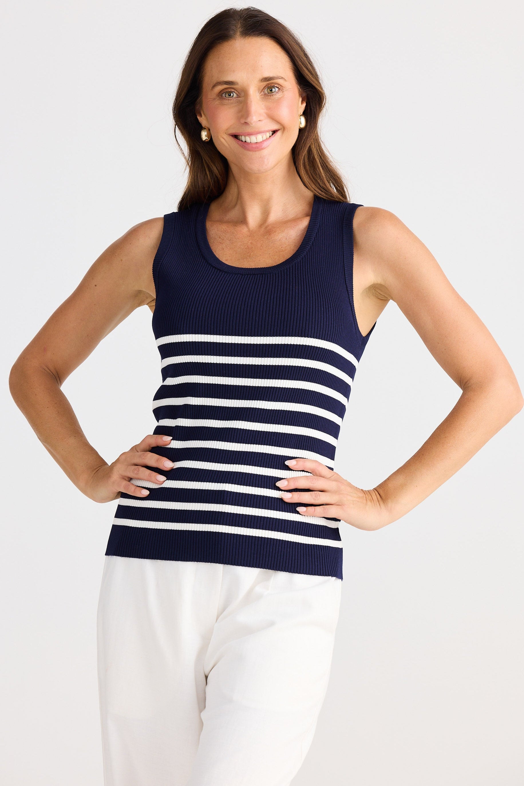 Woman wearing a navy and white striped tank top on a white background