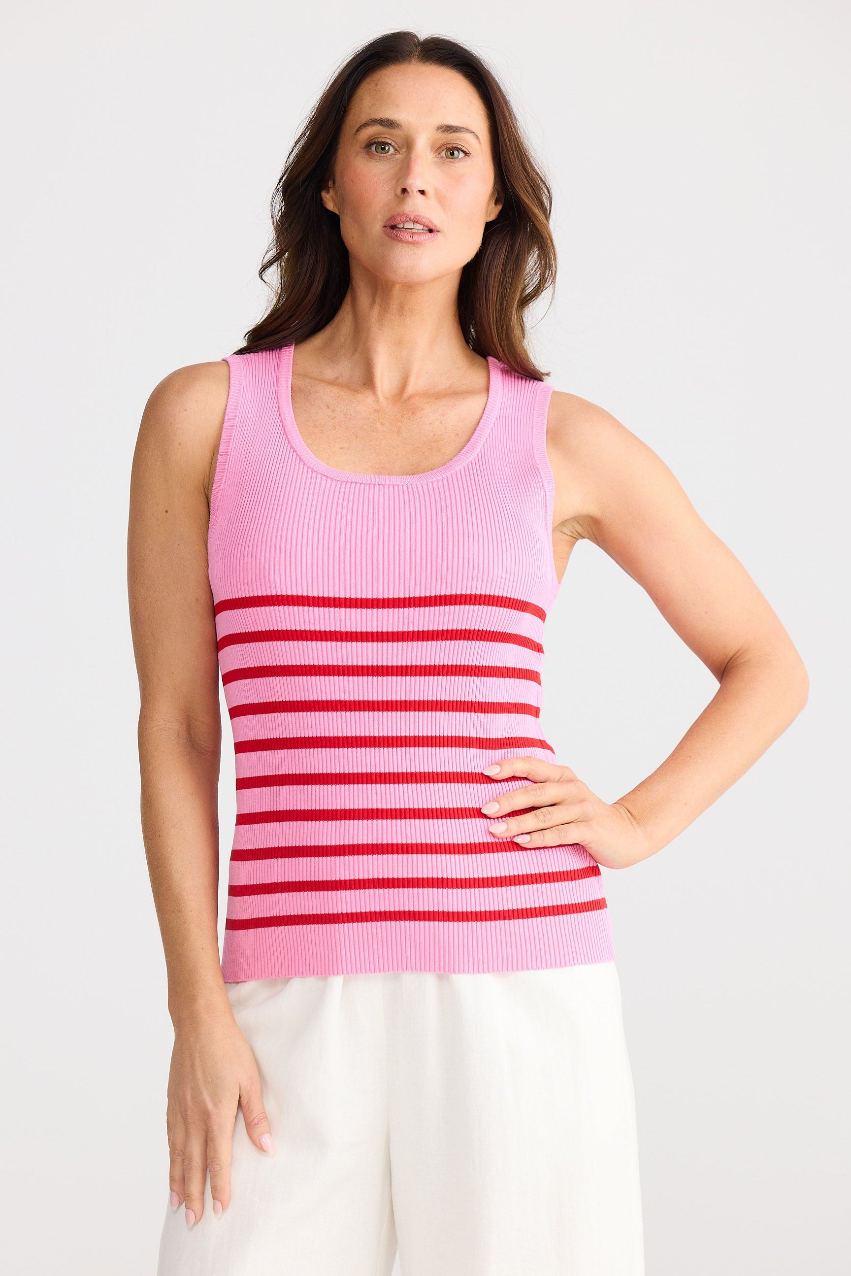 Woman wearing a pink striped tank top against a white background