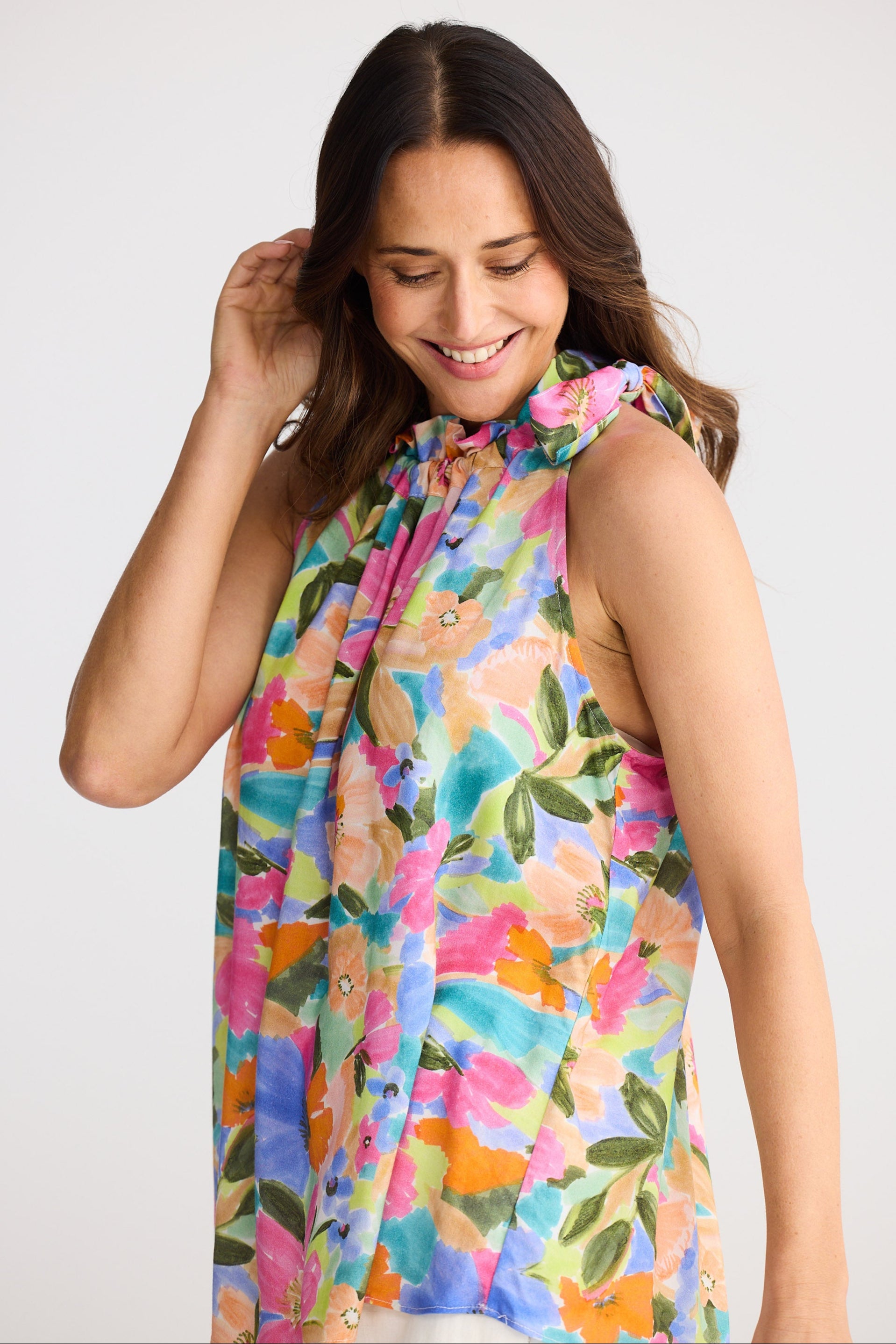 Woman wearing a colorful floral dress against a white background