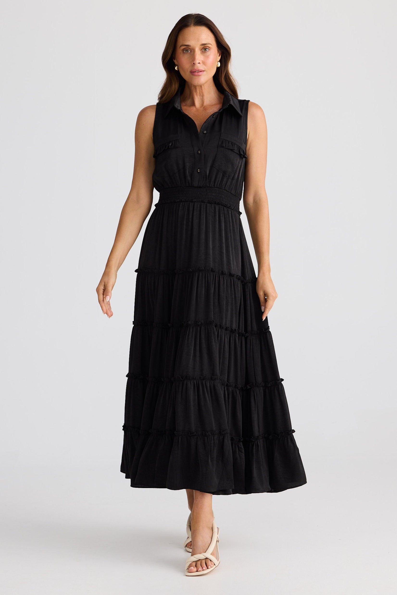 Woman wearing a black tiered dress on a white background