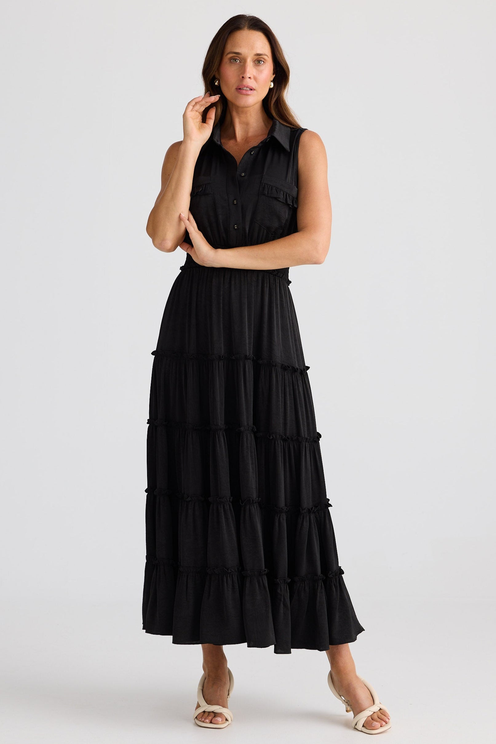 Woman wearing a black tiered dress on a white background