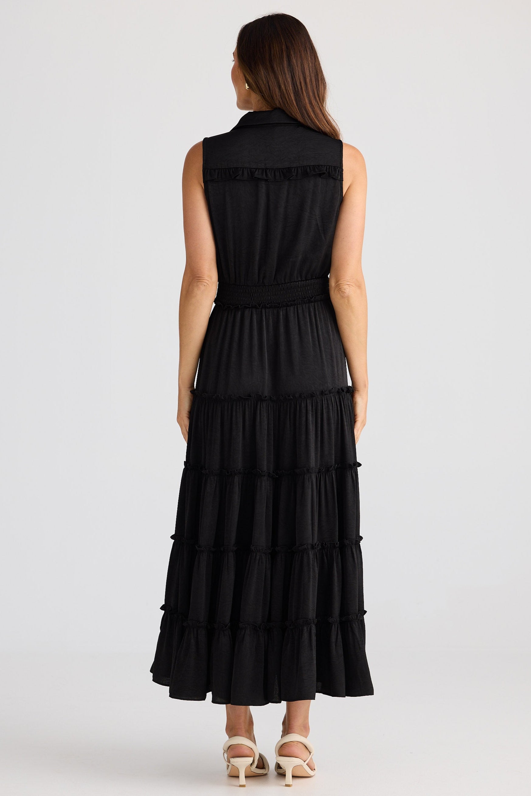 Woman wearing a black tiered dress on a white background