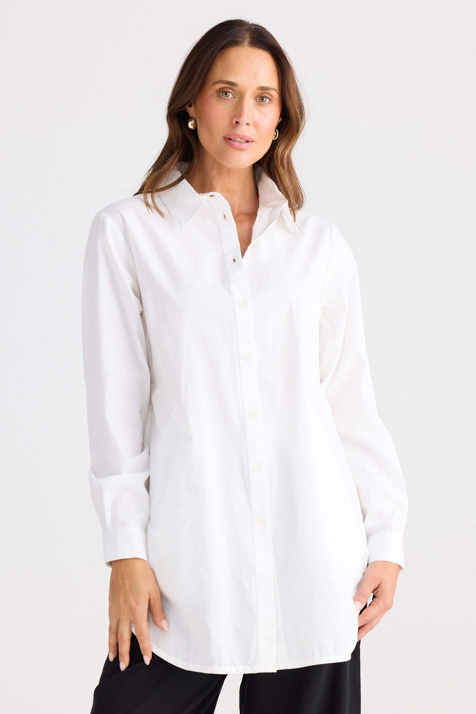 Woman wearing a white shirt and black pants on a white background