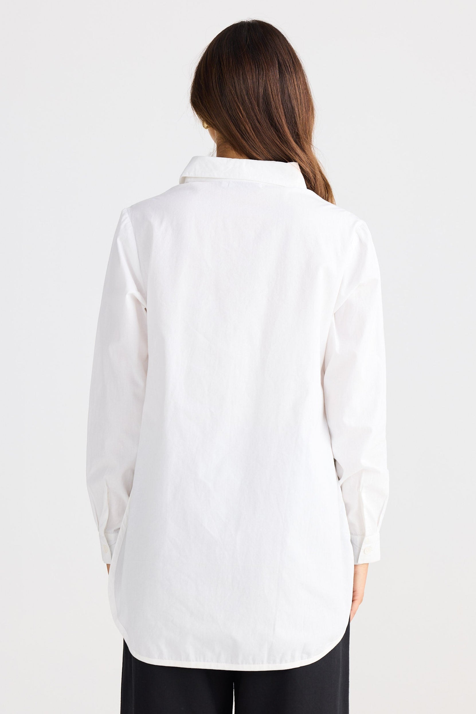 Person wearing a white shirt on a plain background