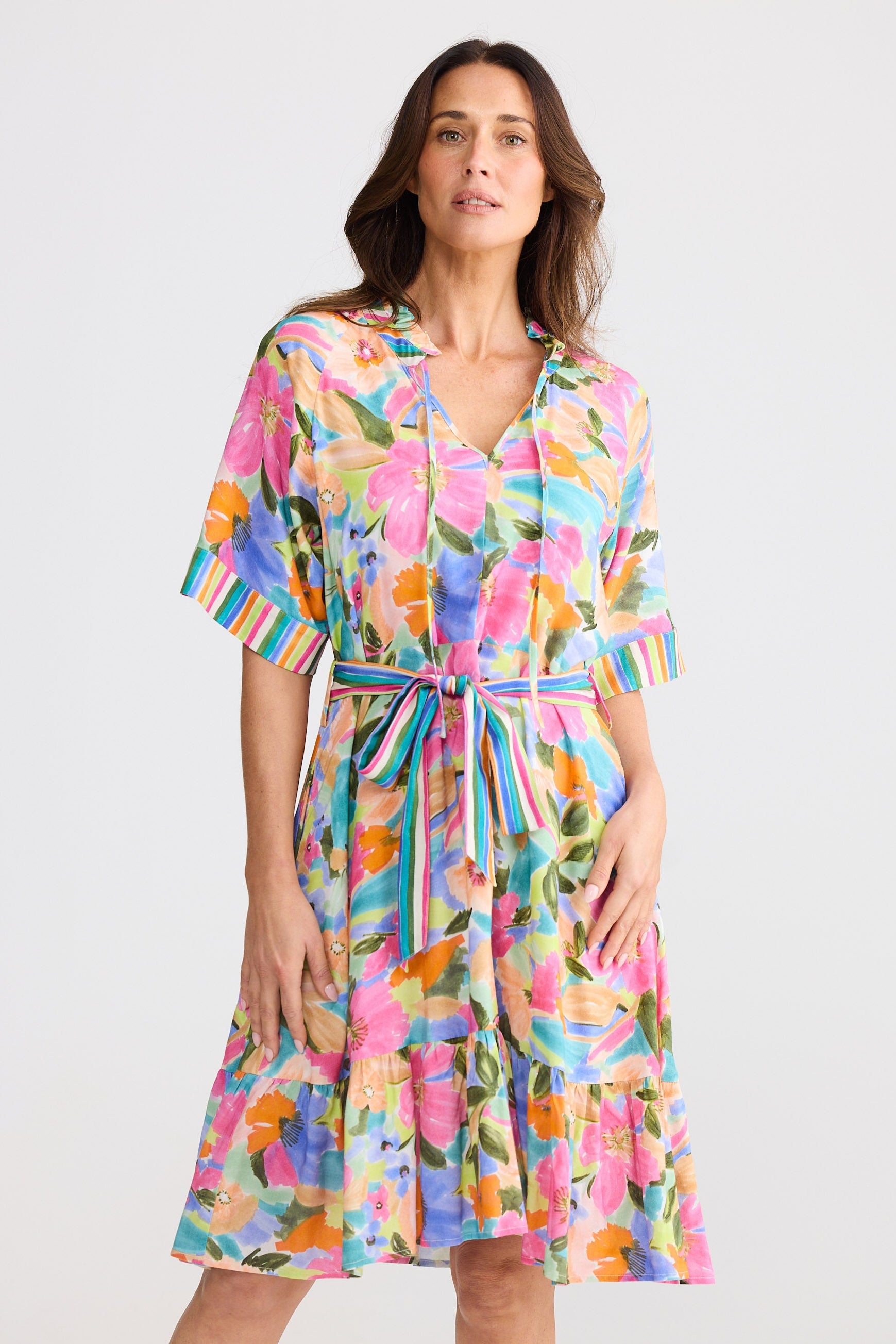 Woman wearing a colorful floral dress on a white background