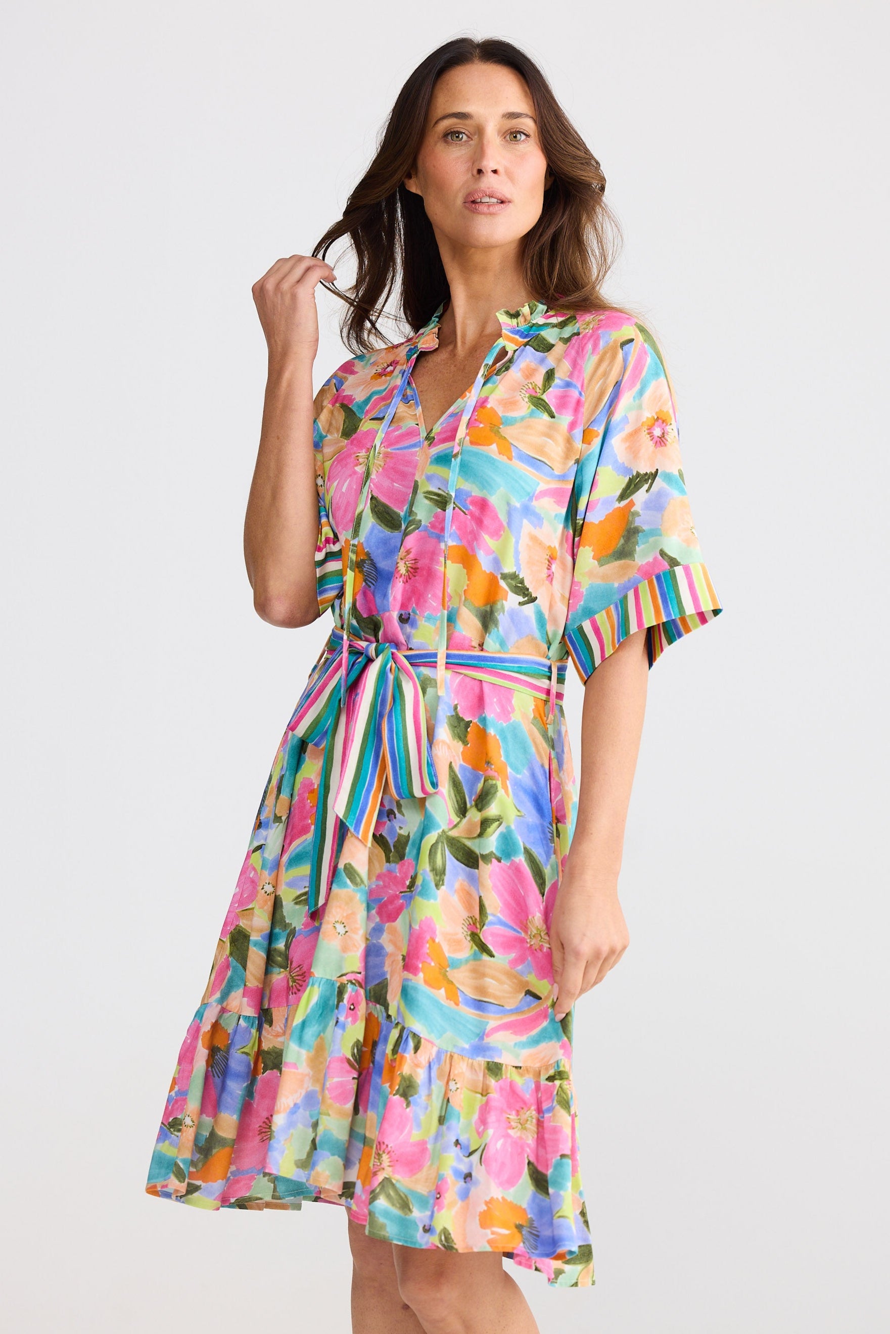 Woman wearing a colorful floral dress on a white background