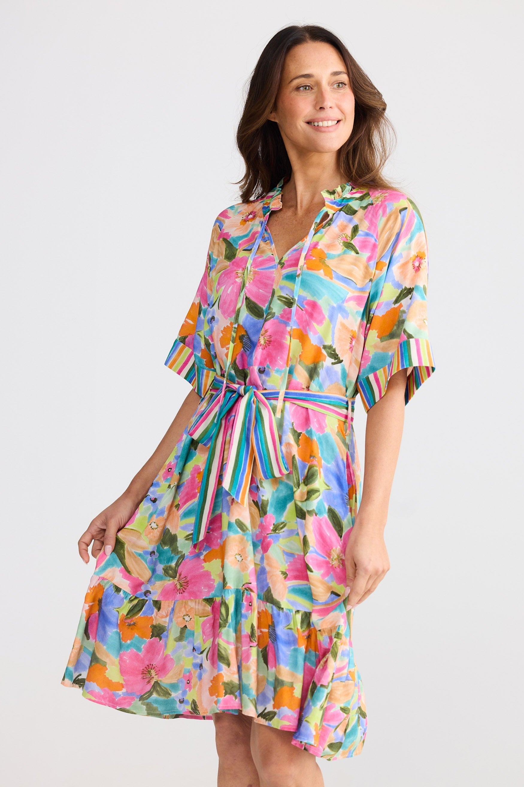 Woman wearing a colorful floral dress on a white background