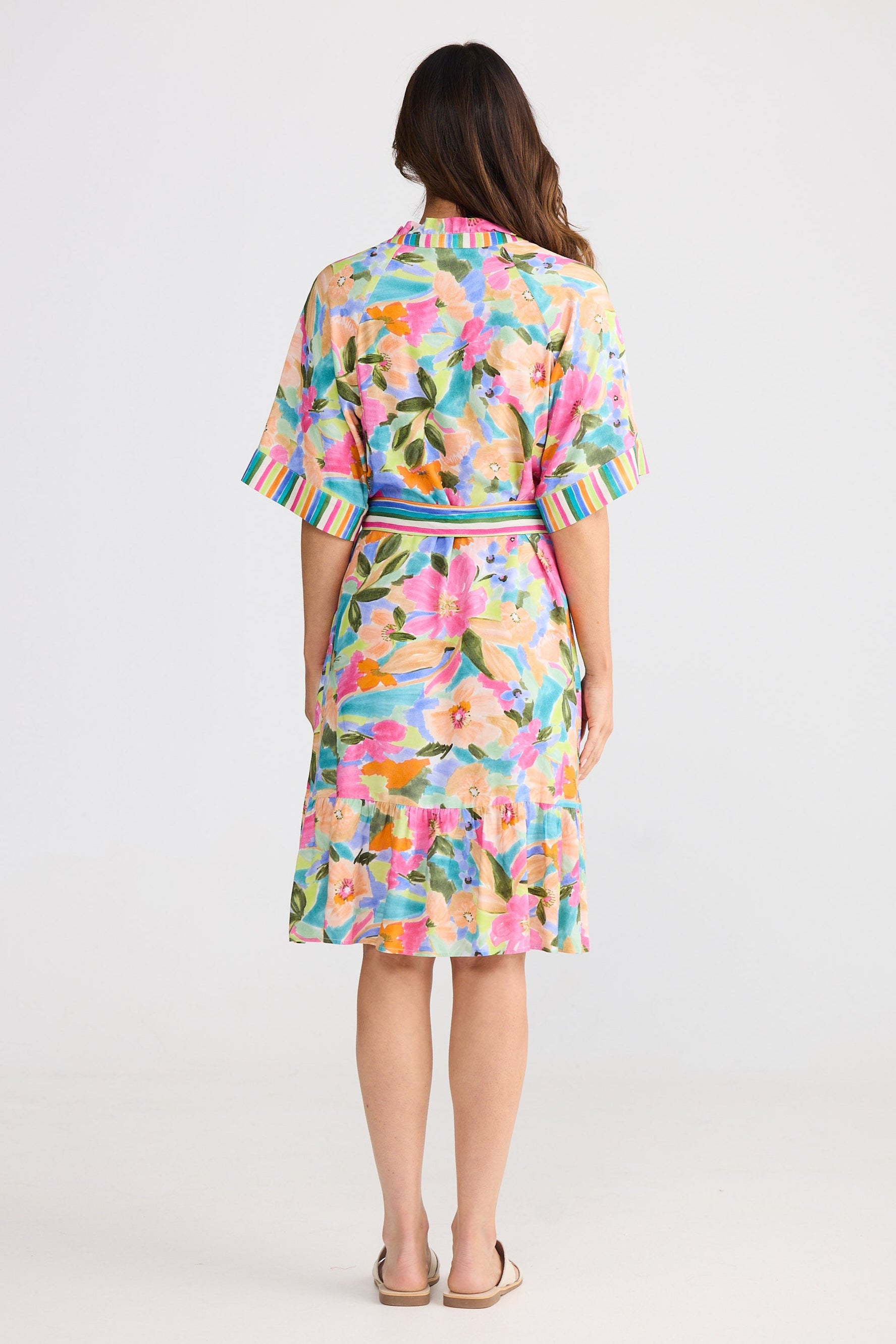 Woman wearing a colorful floral dress on a white background