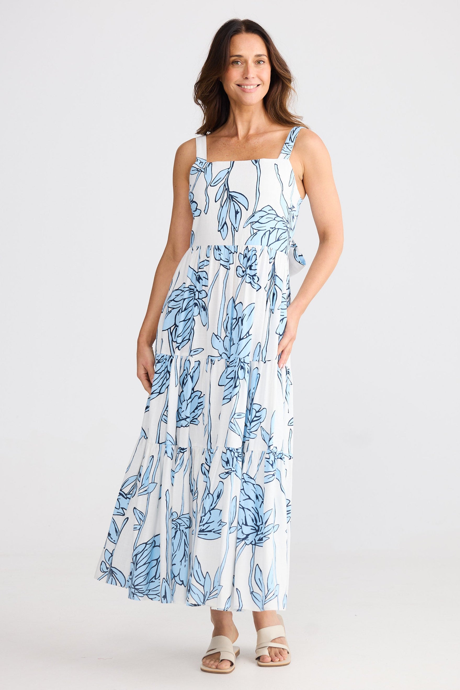 Woman wearing a white dress with blue floral pattern on a white background