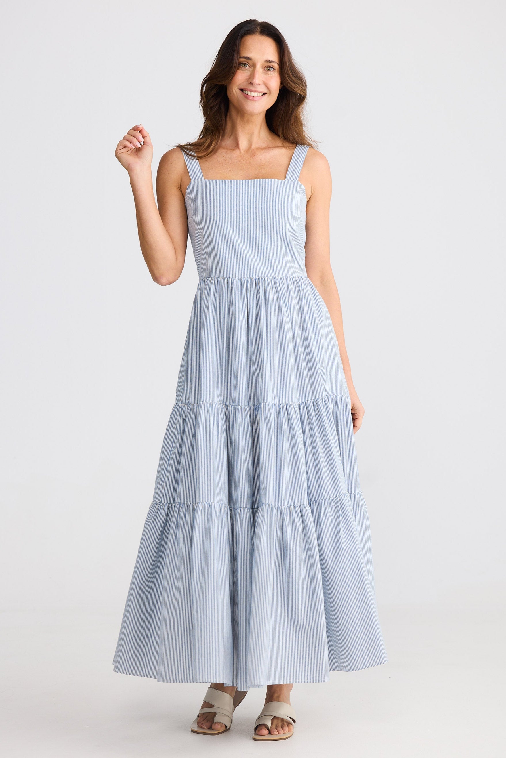Woman wearing a light blue tiered dress on a white background