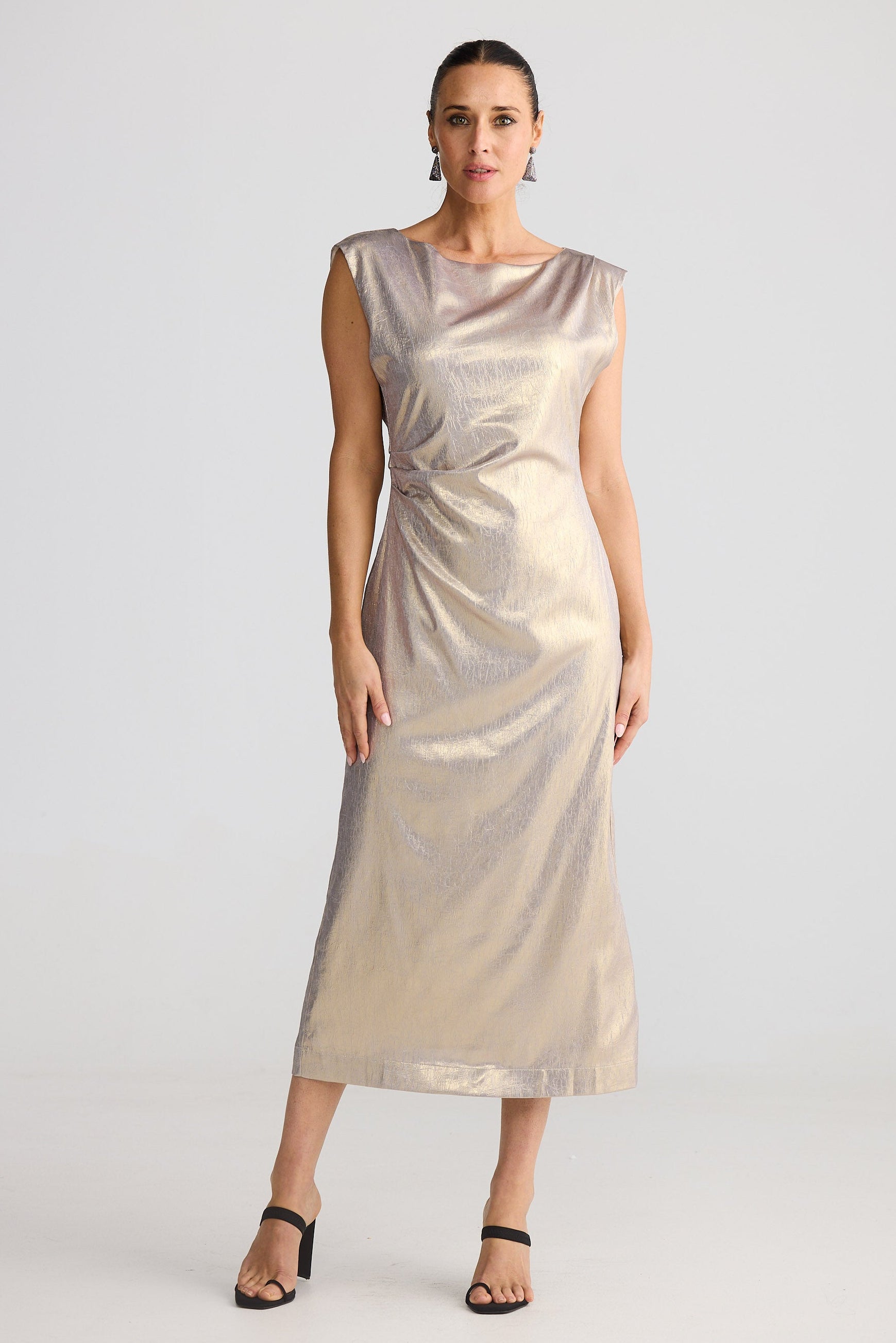 Woman wearing a gold dress against a white background