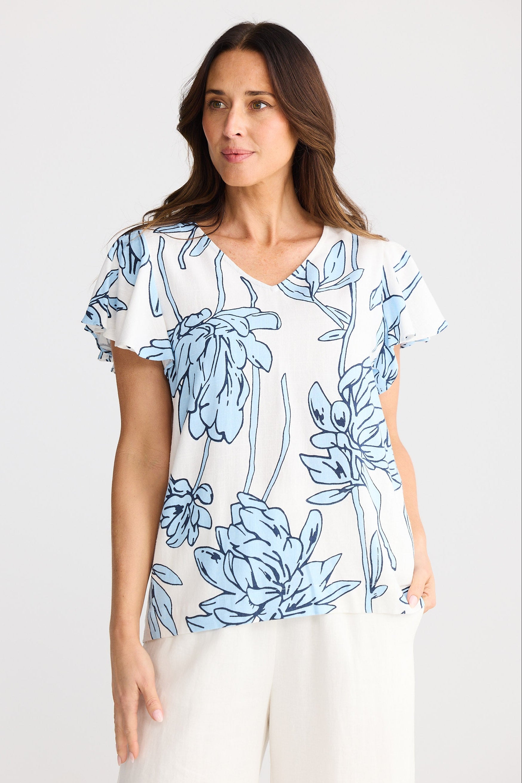 Woman wearing a blue floral patterned shirt on a white background