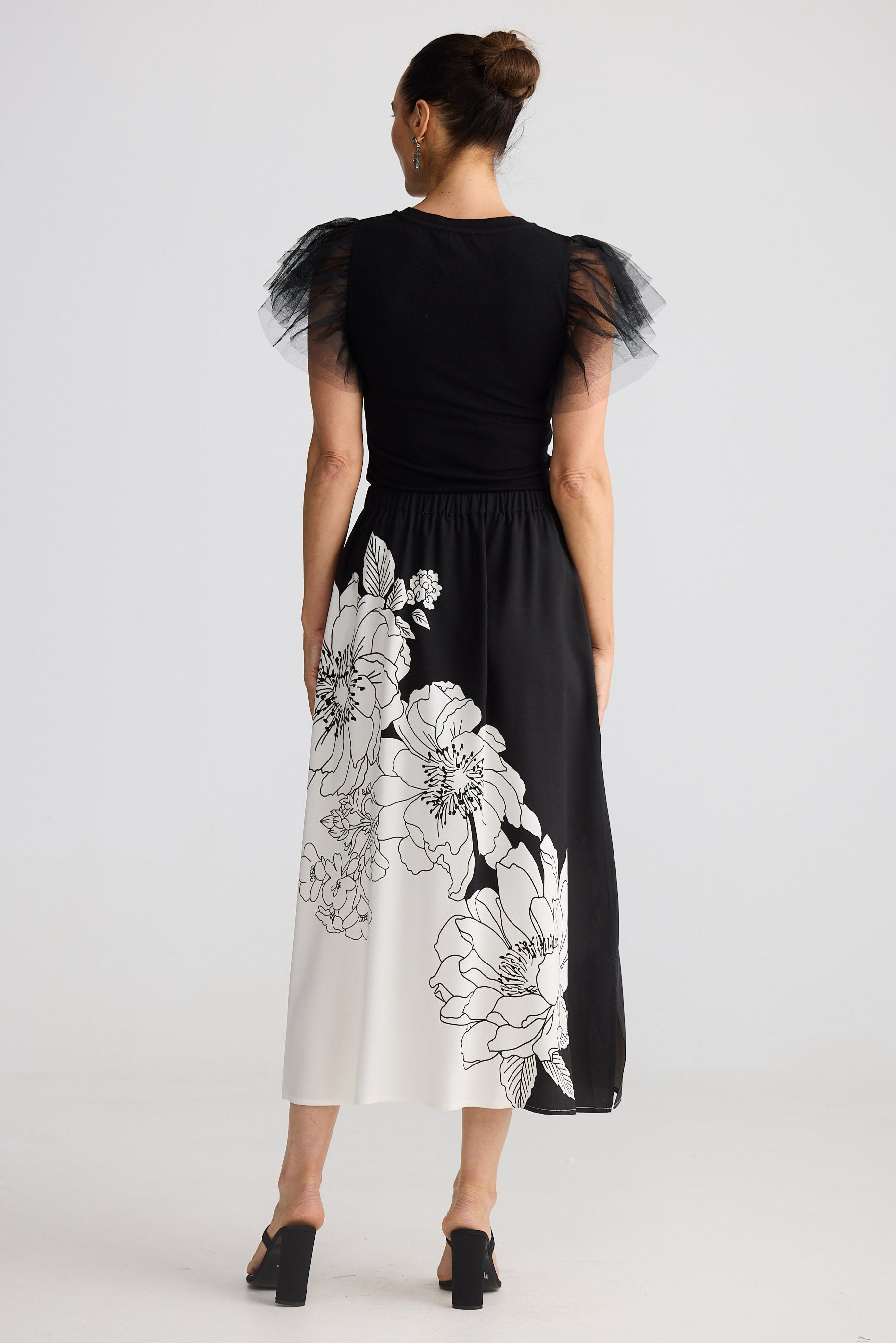 Woman wearing a black and white floral dress on a white background