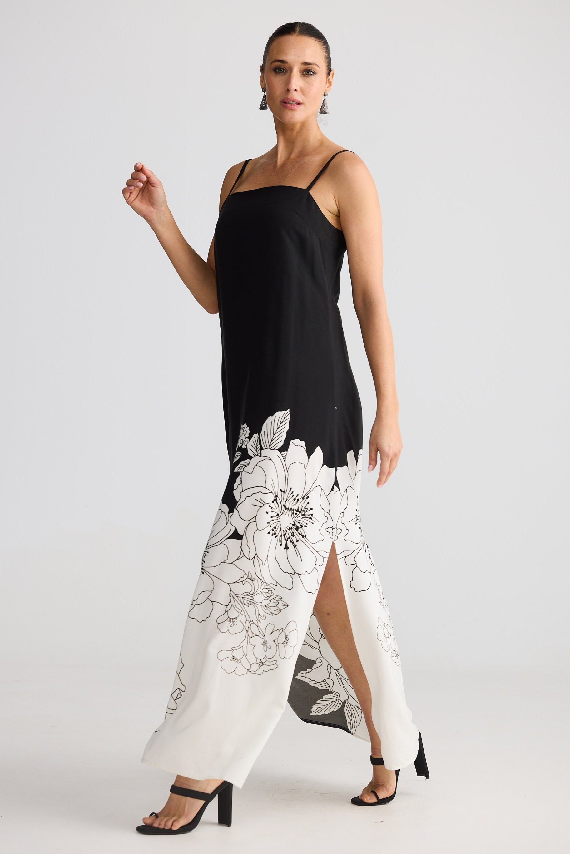 Woman wearing a black and white floral dress on a plain background