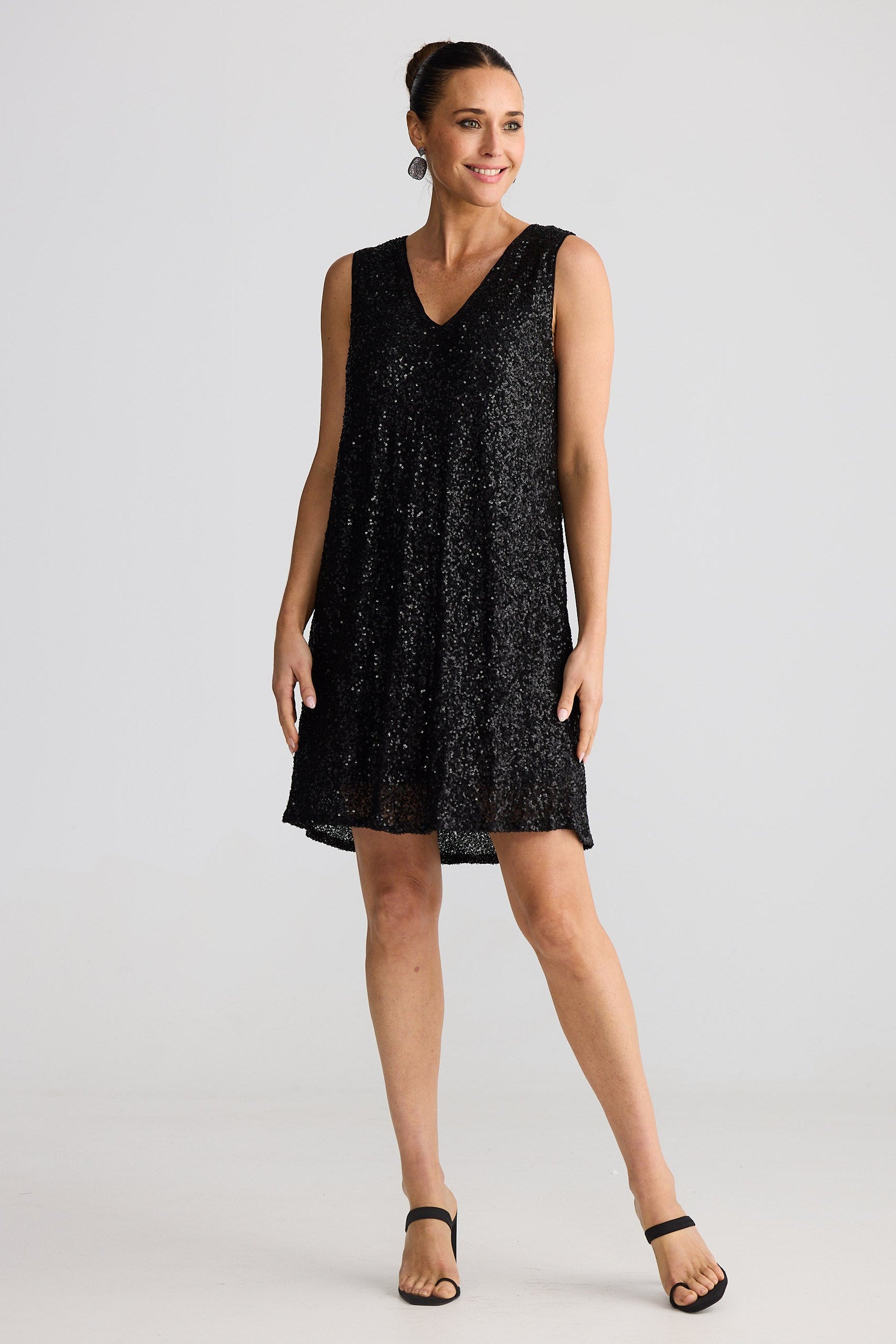 Woman wearing a black sleeveless dress on a white background