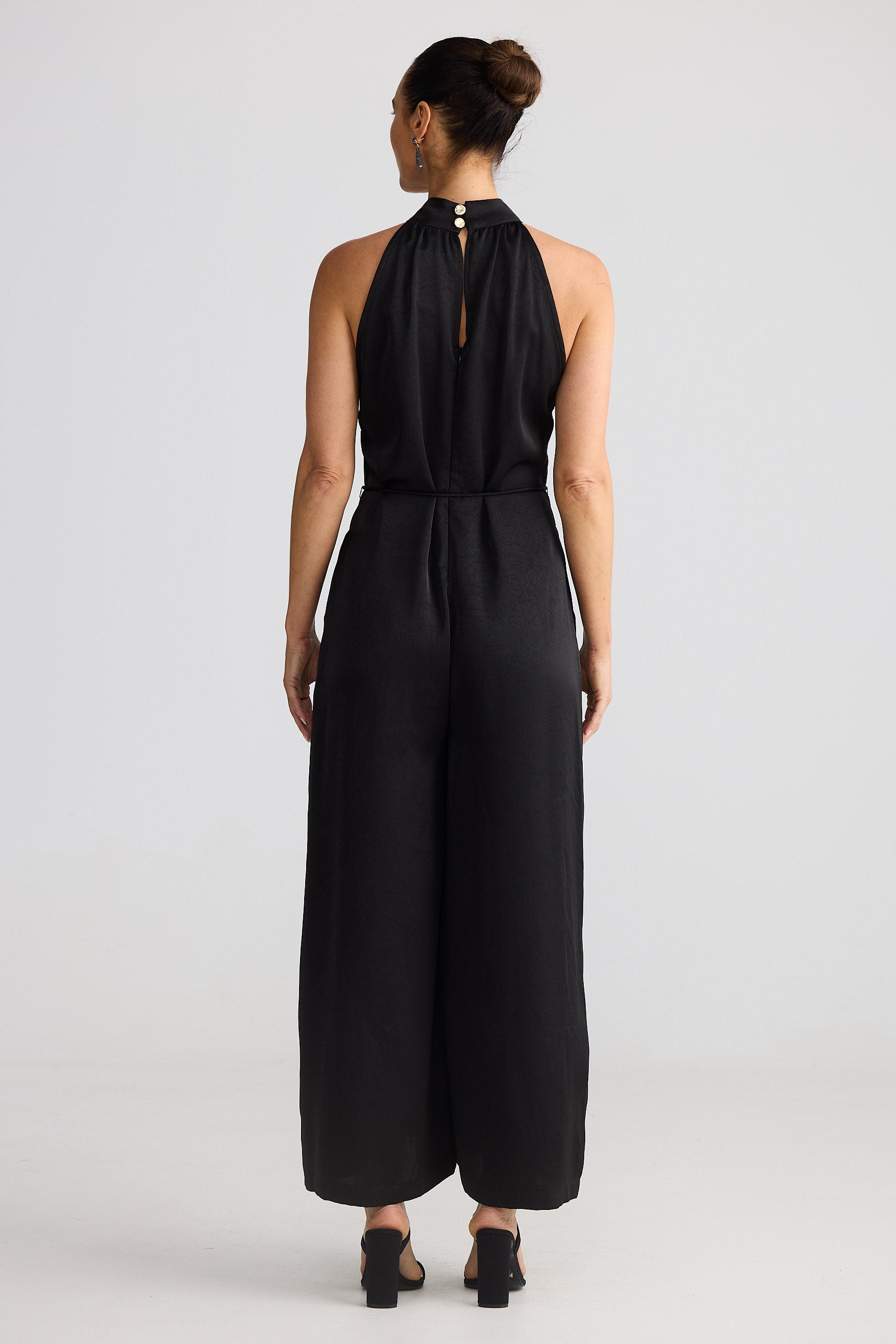 Person wearing a black jumpsuit on a white background