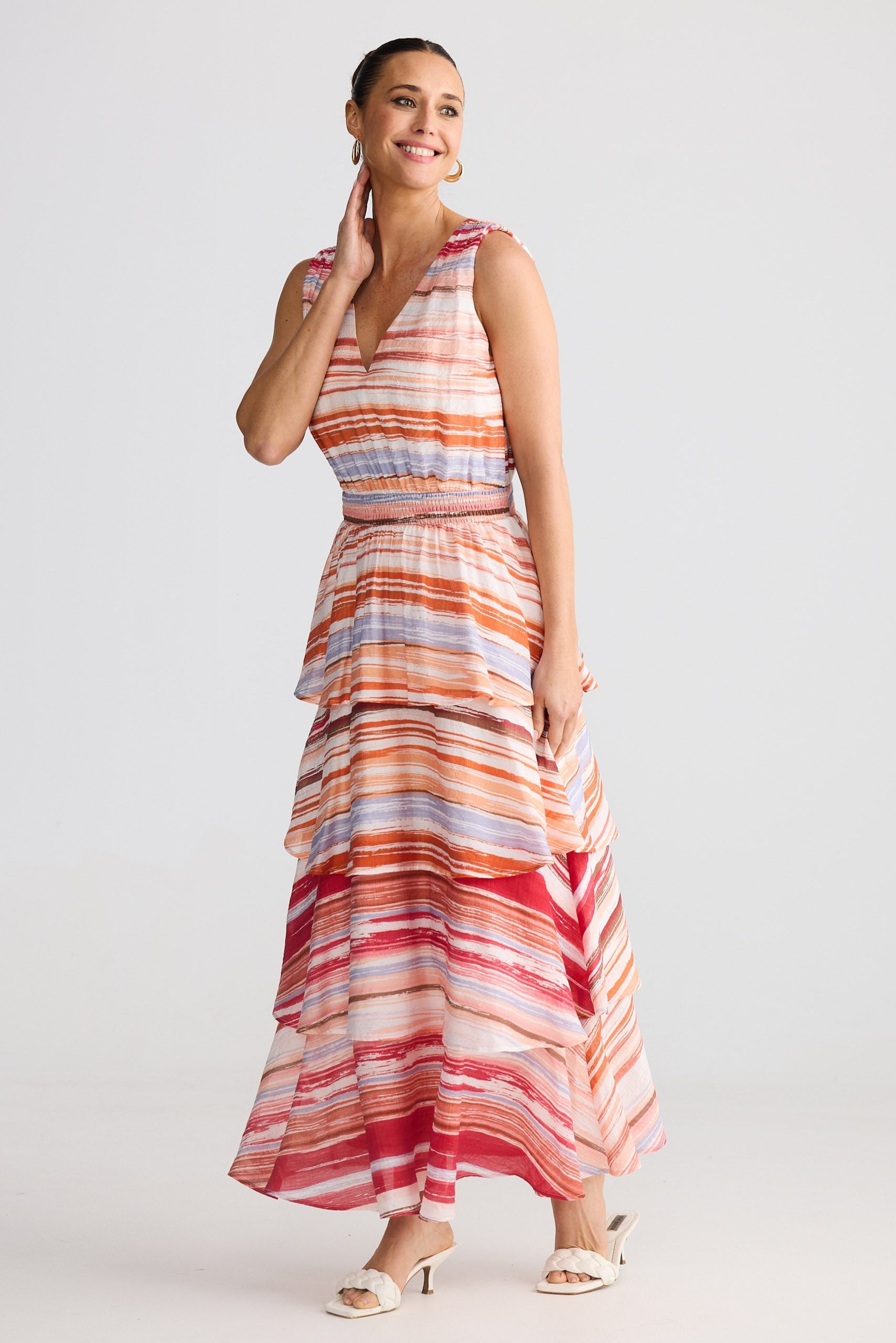 Woman wearing a colorful striped dress on a white background