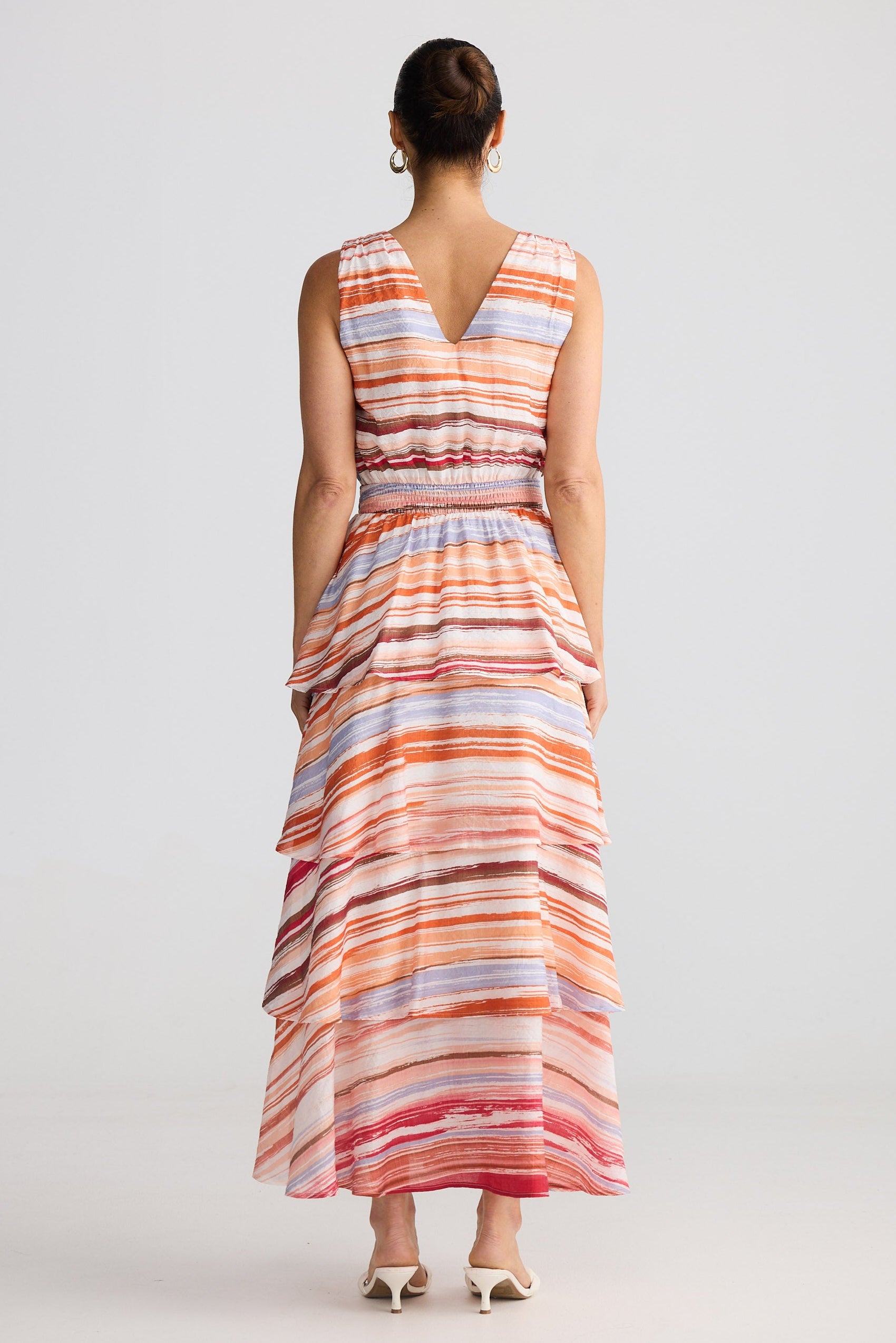 Woman wearing a striped dress on a plain background