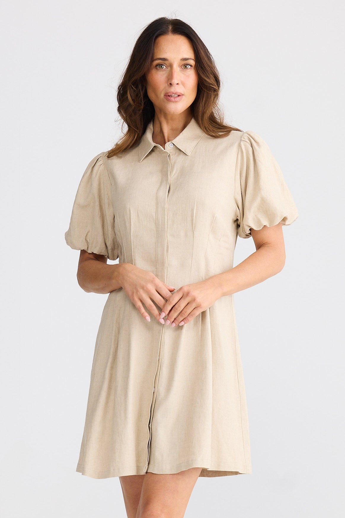 Woman wearing a beige dress on a white background