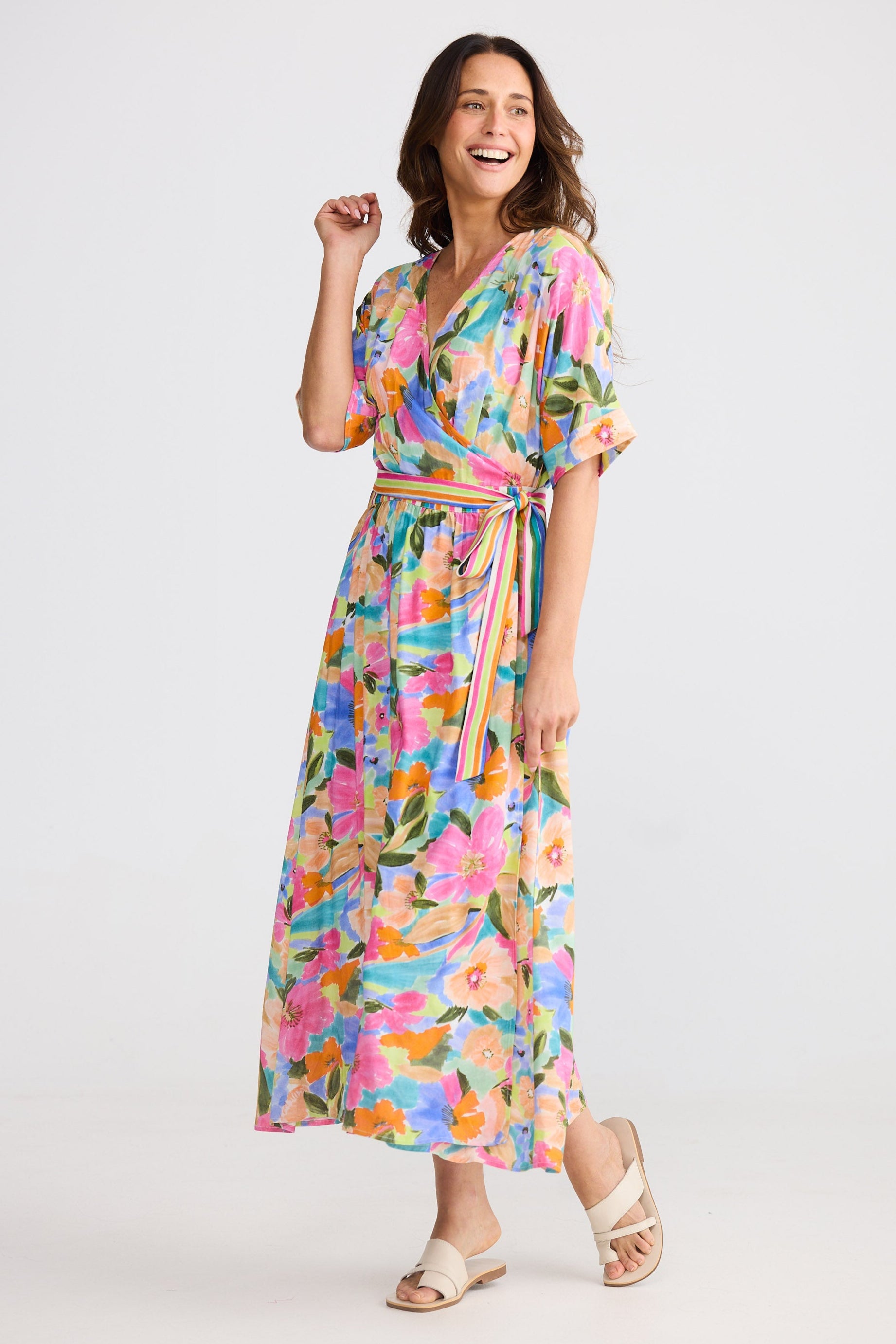 Woman wearing a colorful floral dress on a white background