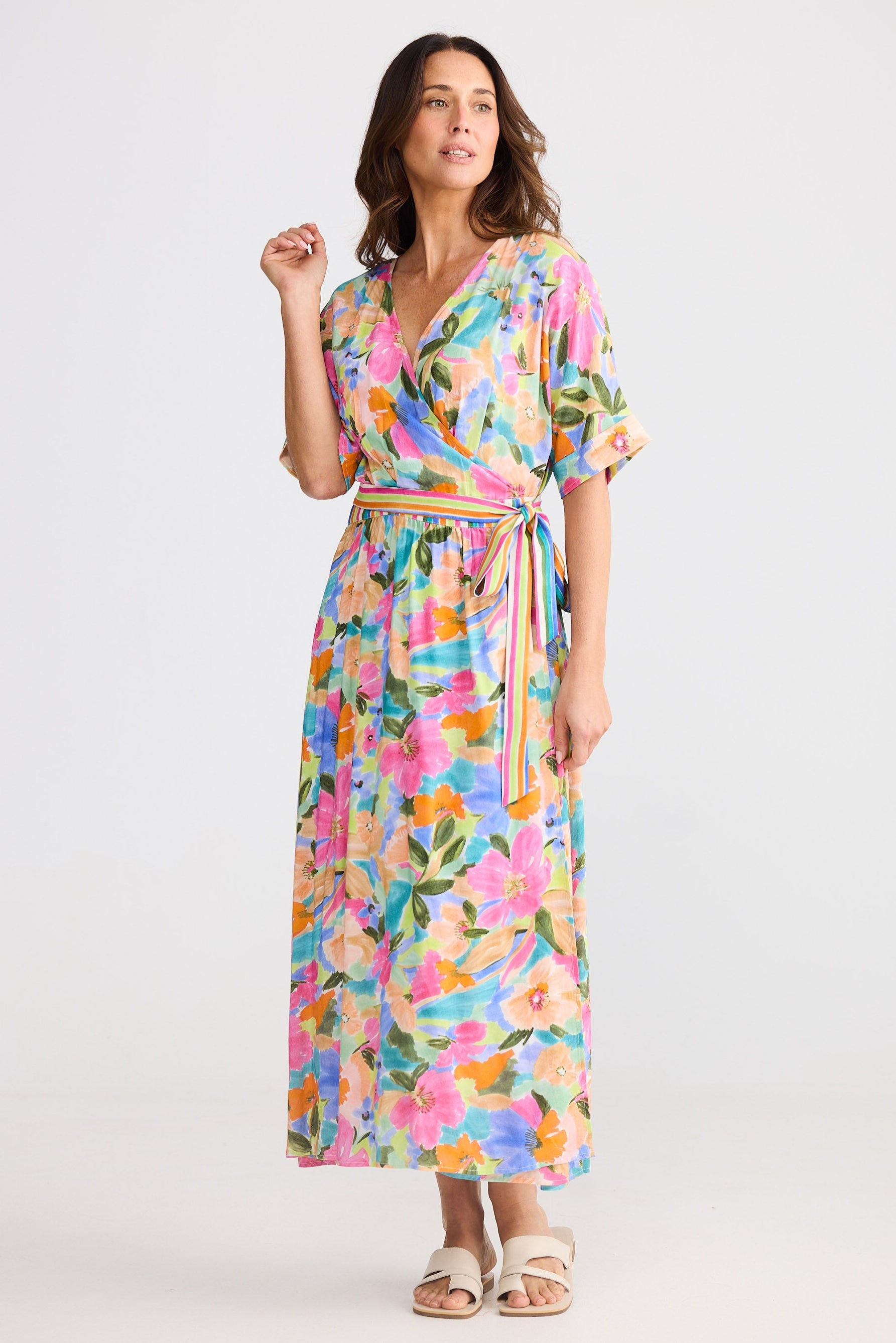 Woman wearing a colorful floral dress on a white background