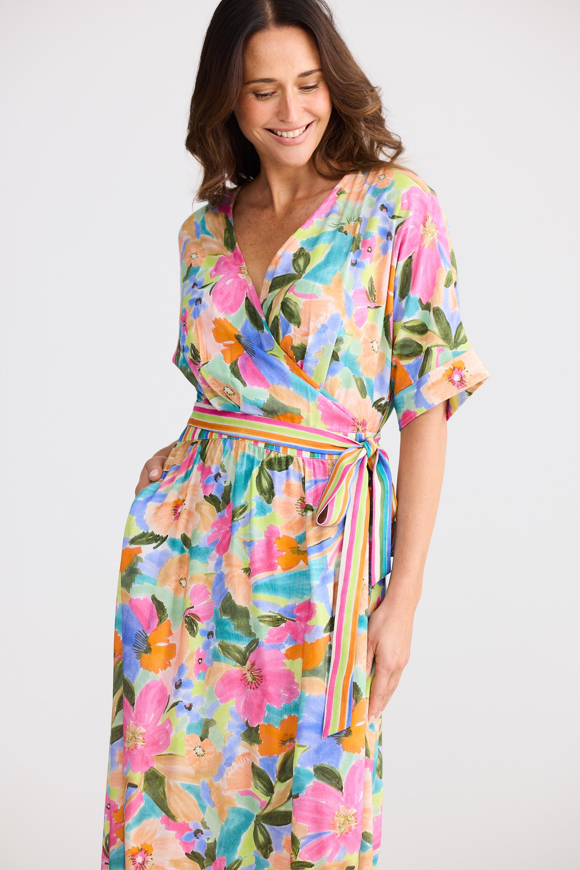 Woman wearing a colorful floral dress on a white background