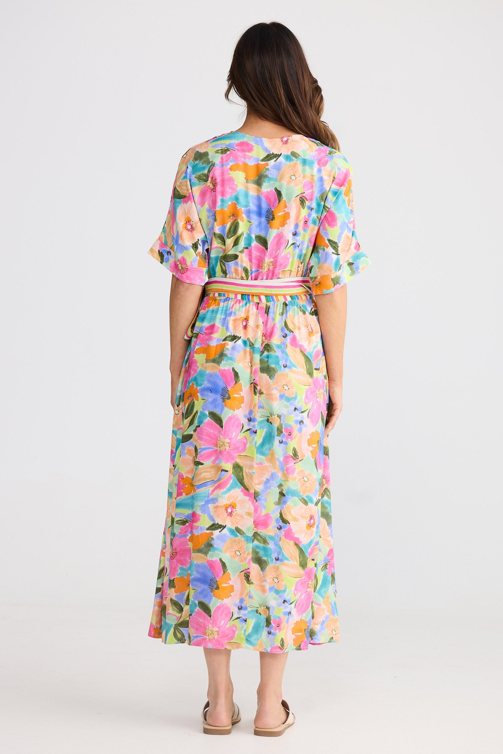 Woman wearing a colorful floral dress on a white background