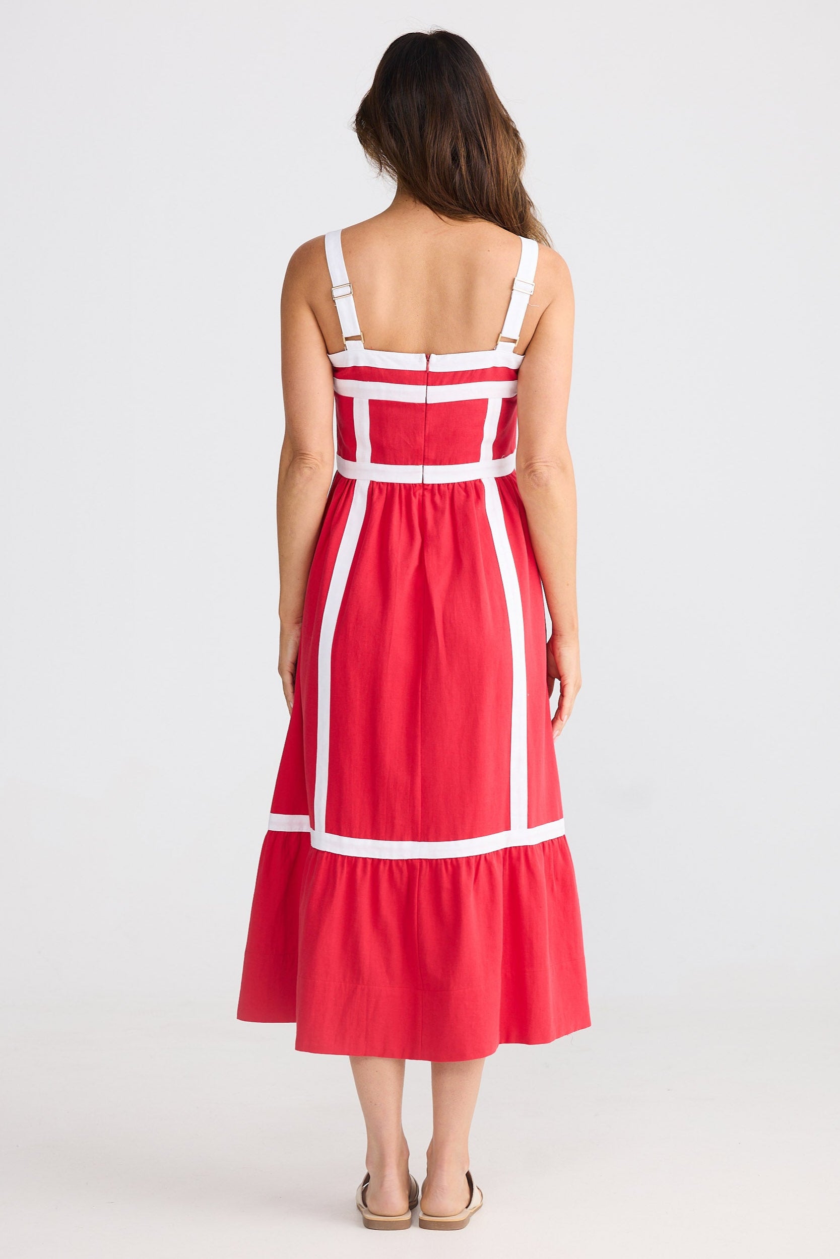 Woman wearing a red dress with white accents on a white background