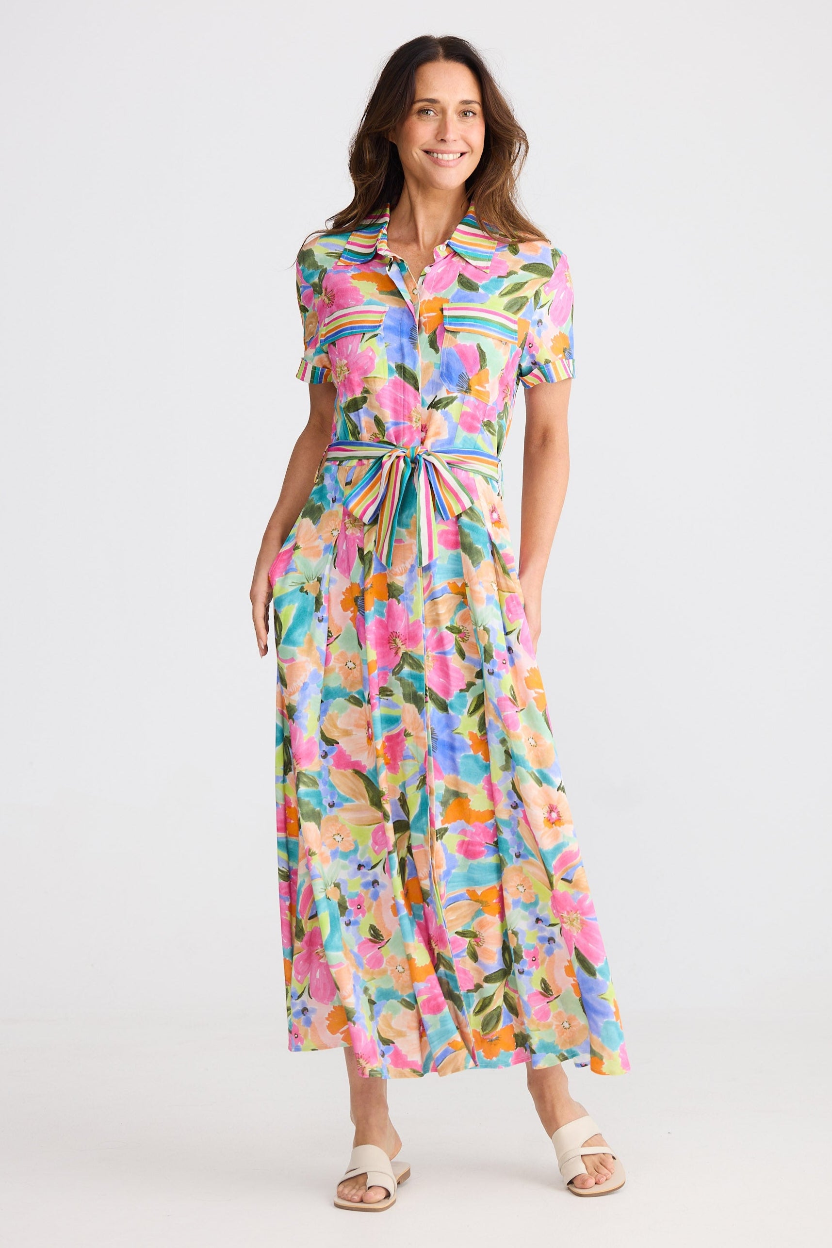 Woman wearing a colorful floral dress on a white background