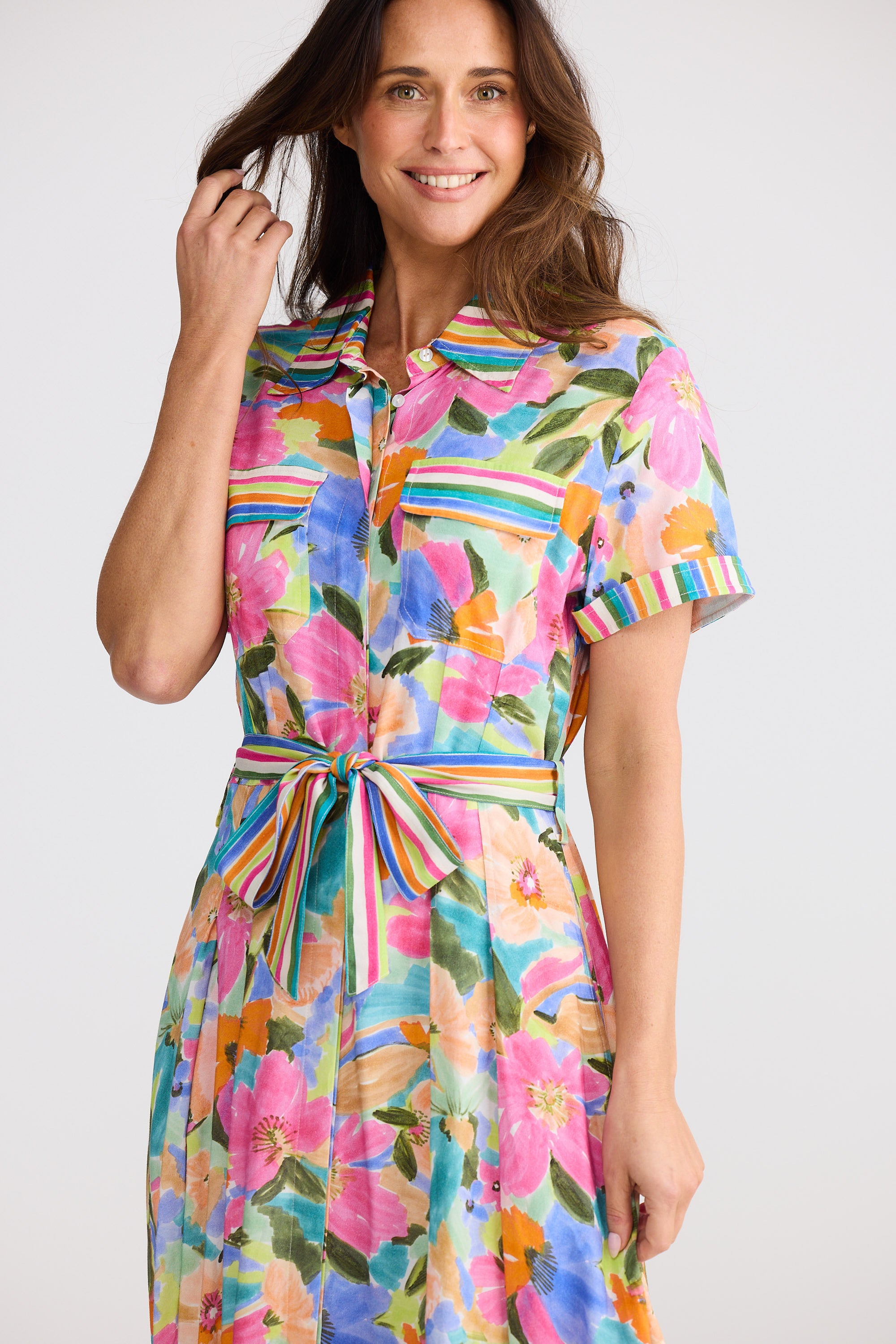 Woman wearing a colorful floral dress with a white background