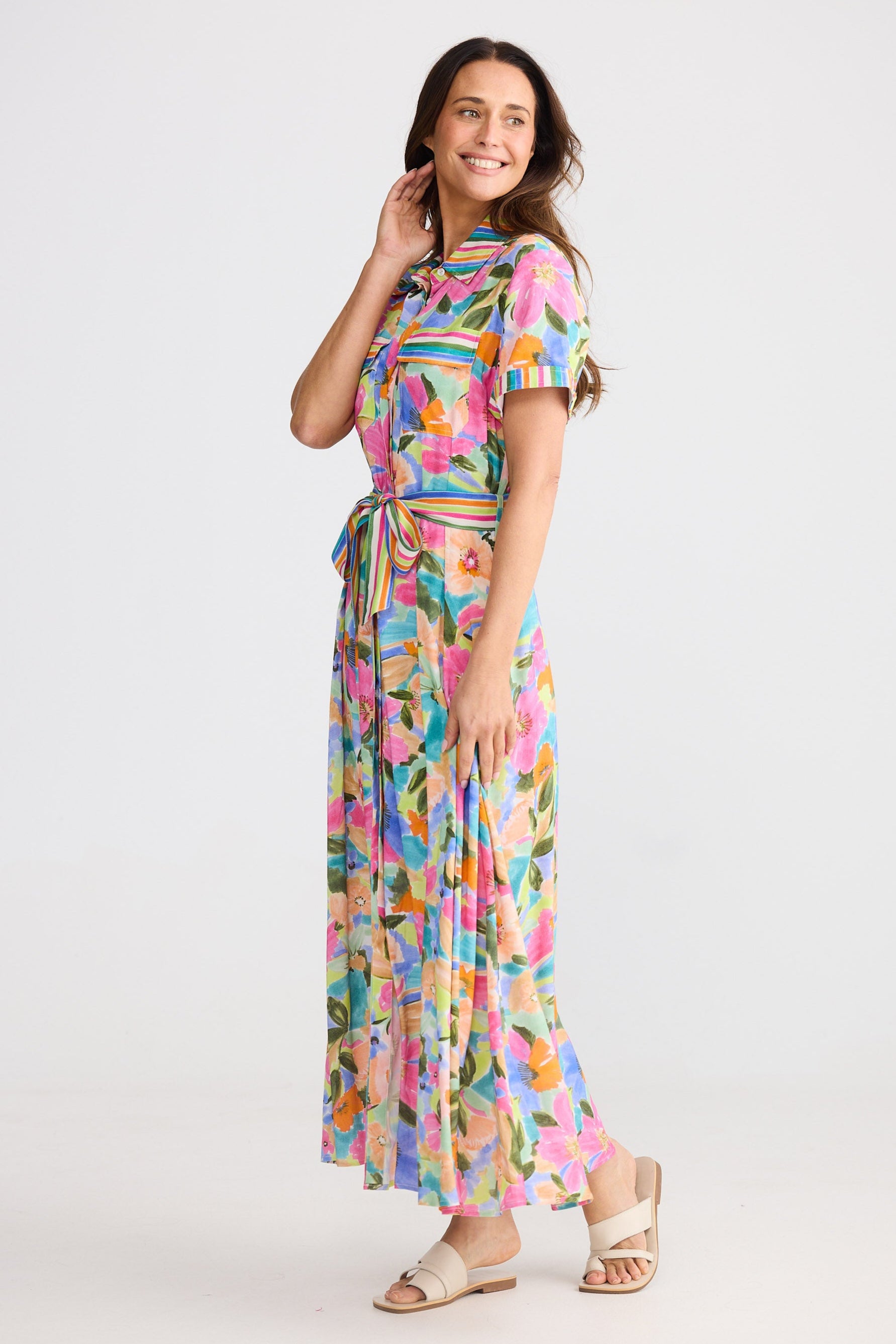 Woman wearing a colorful floral dress on a white background