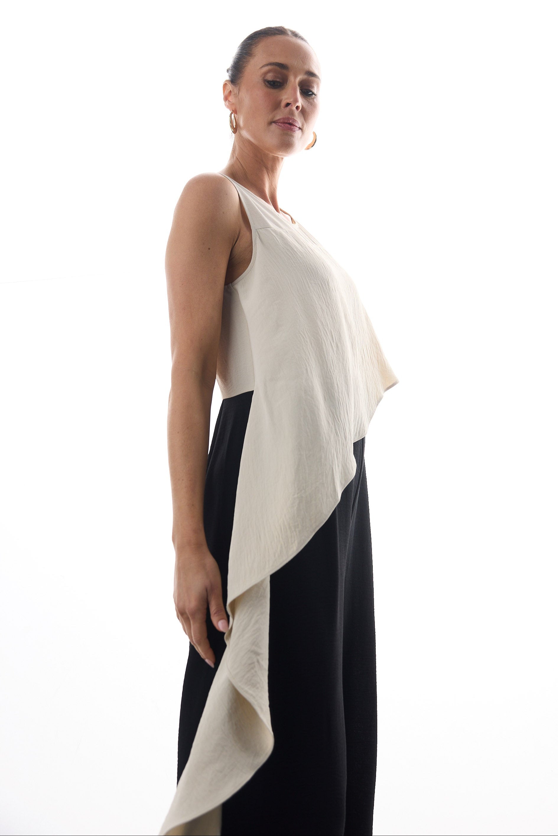 Woman wearing a beige and black sleeveless pantsuit on a white background