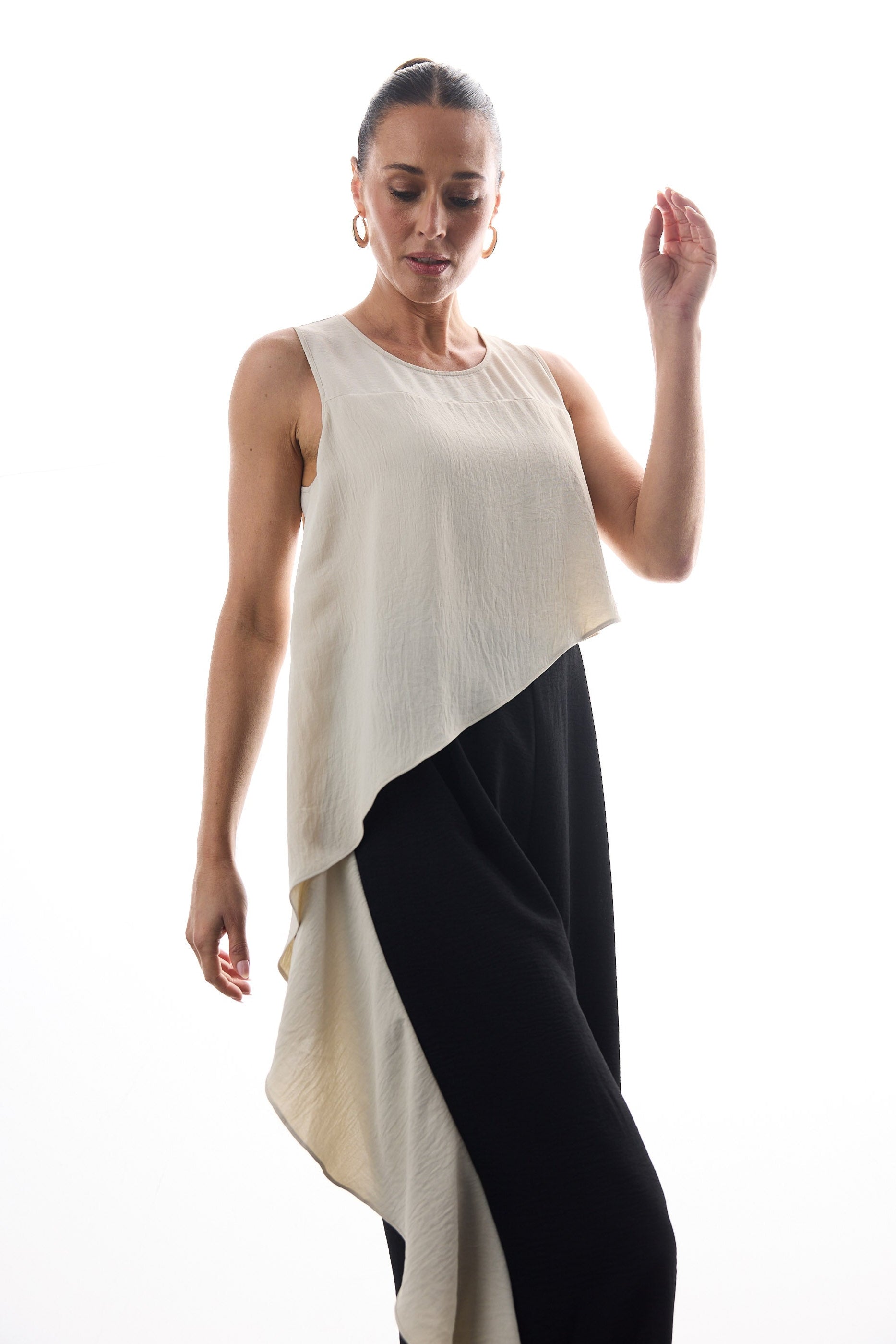 Woman wearing a beige and black sleeveless pantsuit on a white background